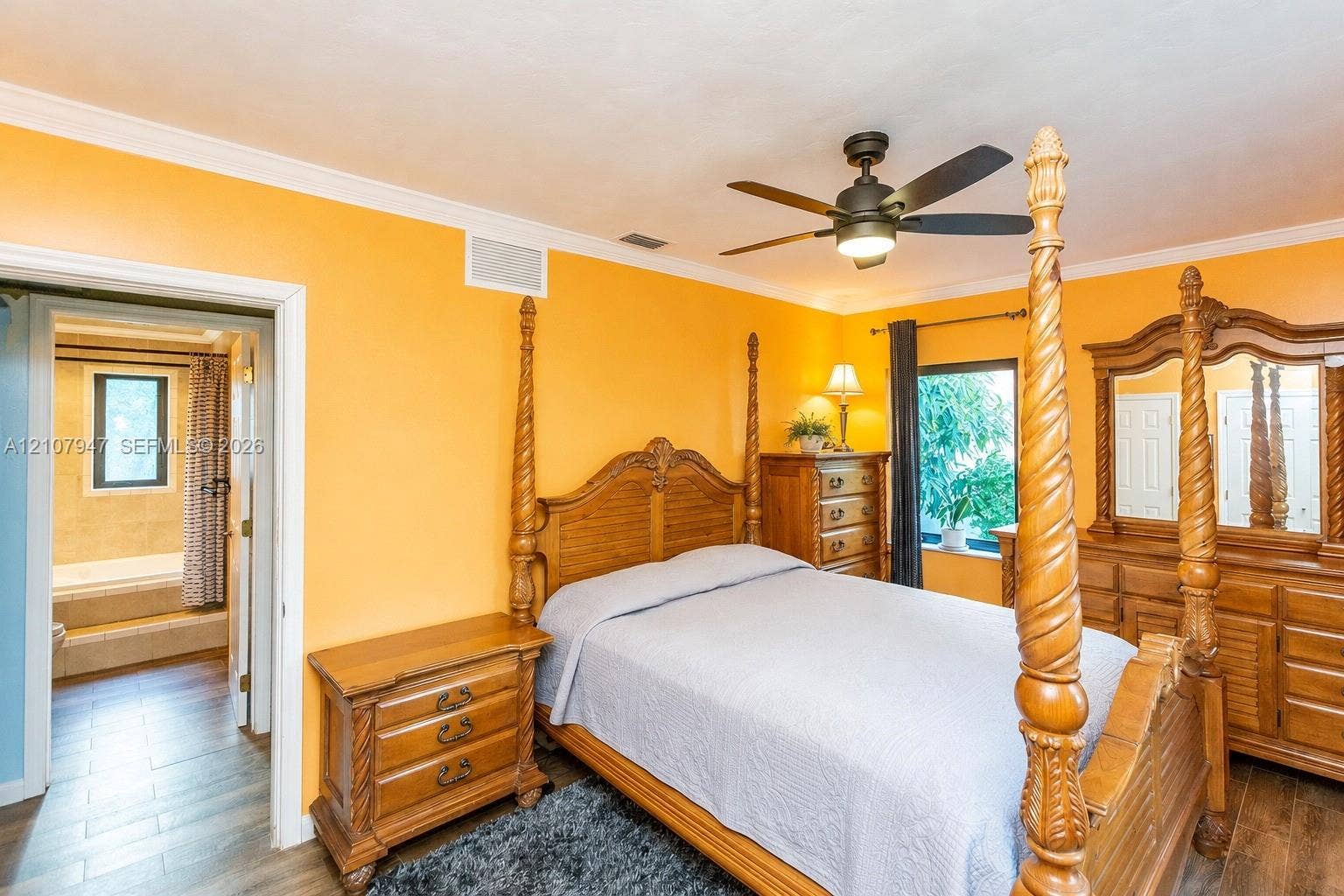 Room featuring wood-finish flooring, crown molding, and a ceiling fan with integrated lighting