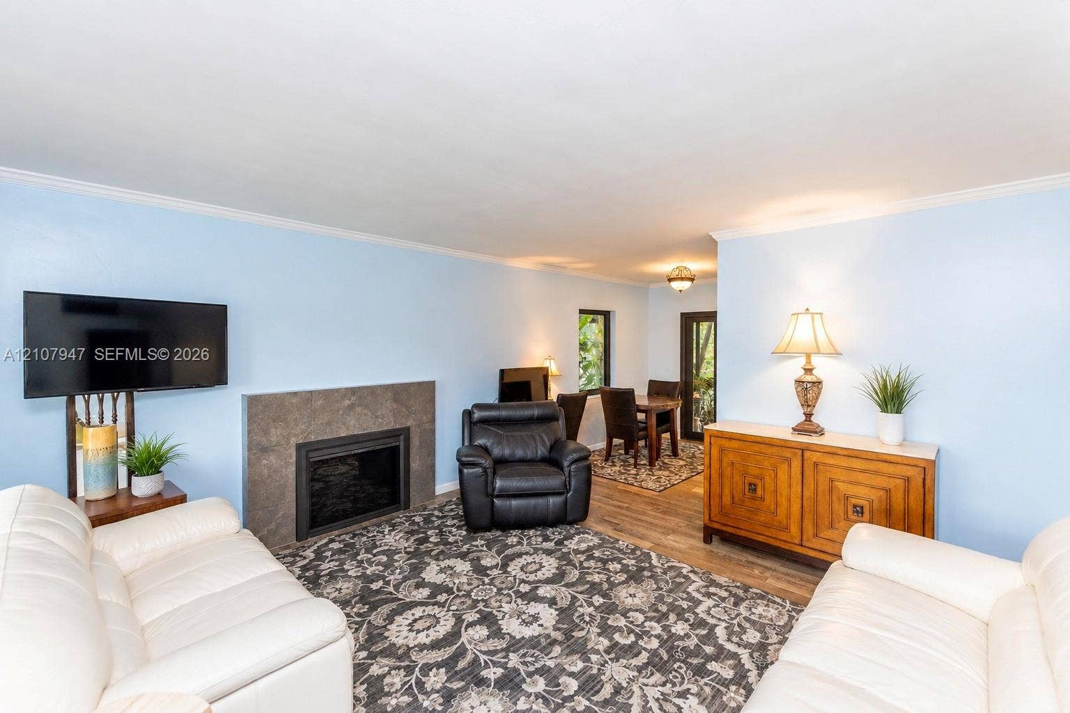 Living area featuring wood-finish flooring and a fireplace with a stone-finish surround