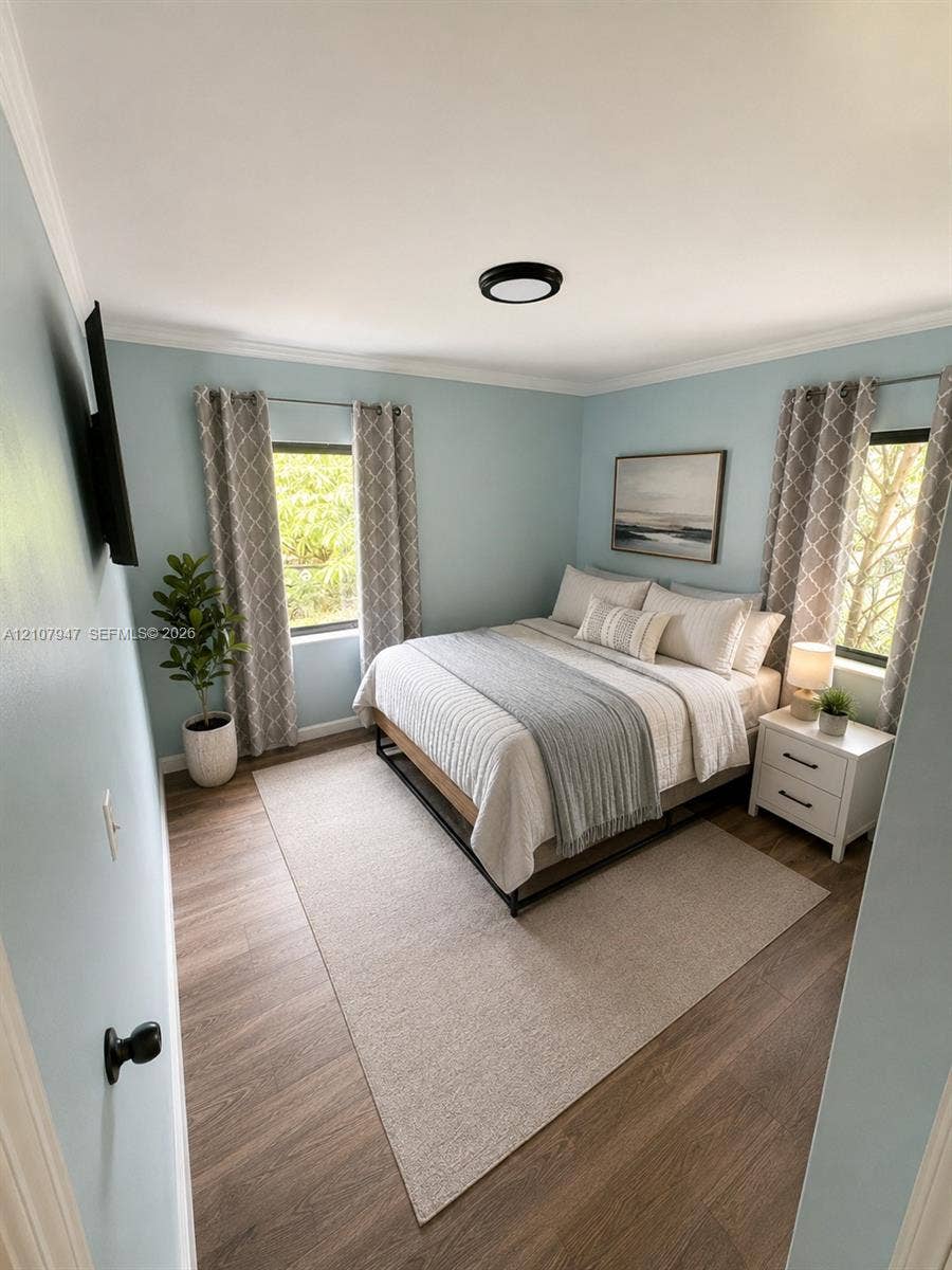 Room featuring wood-finish flooring, two windows, and a flush-mount ceiling light fixture