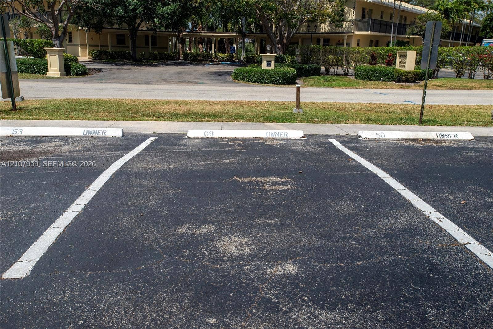 4200 Crystal Lake Drive, #204, Deerfield Beach, Deerfield Beach, FL 33064 Asphalt parking area with three designated surface parking spaces and painted wheel stops