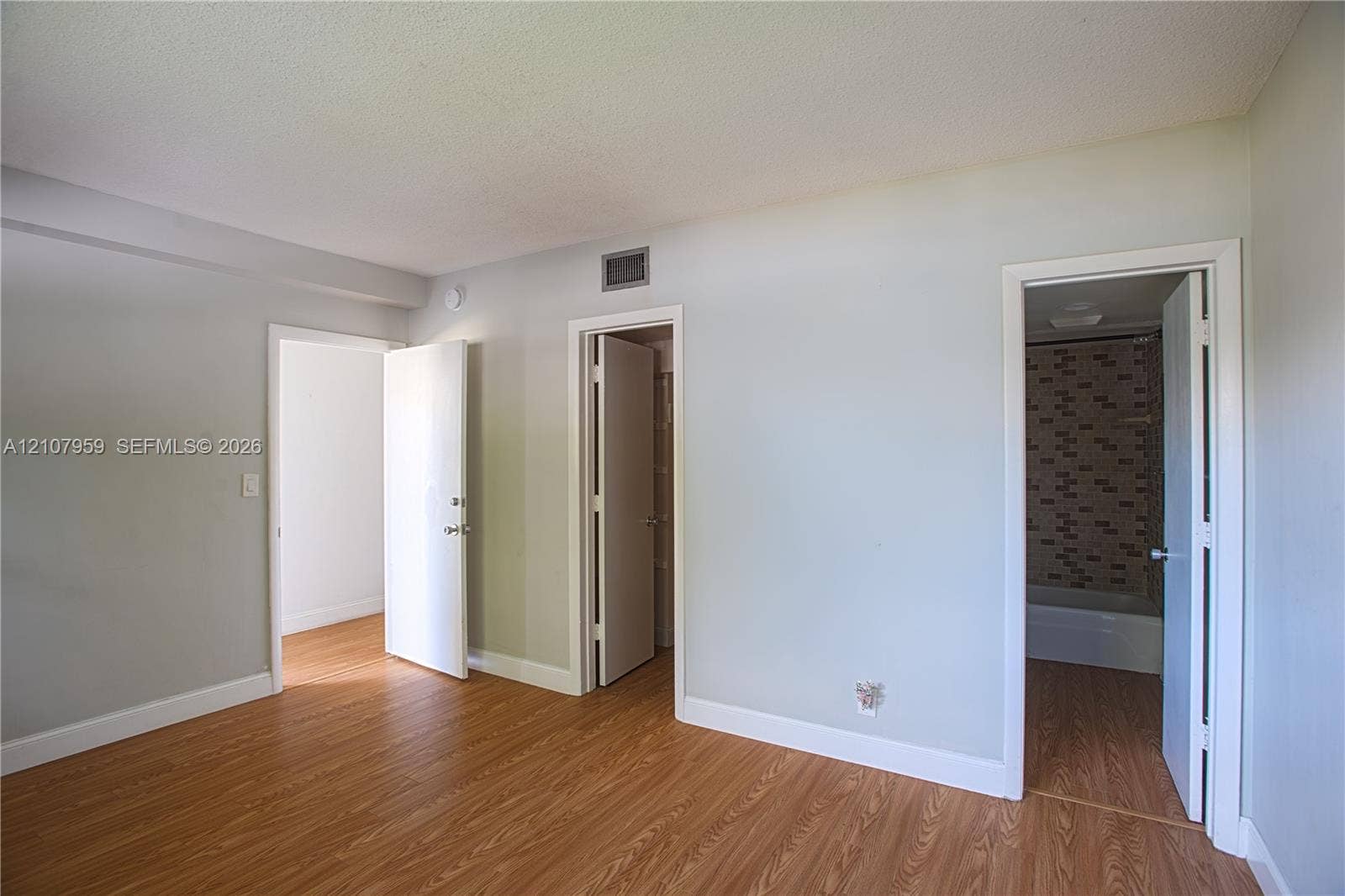 4200 Crystal Lake Drive, #204, Deerfield Beach, Deerfield Beach, FL 33064 Wood-finish flooring, neutral wall tones, and doorways featuring interior slab doors