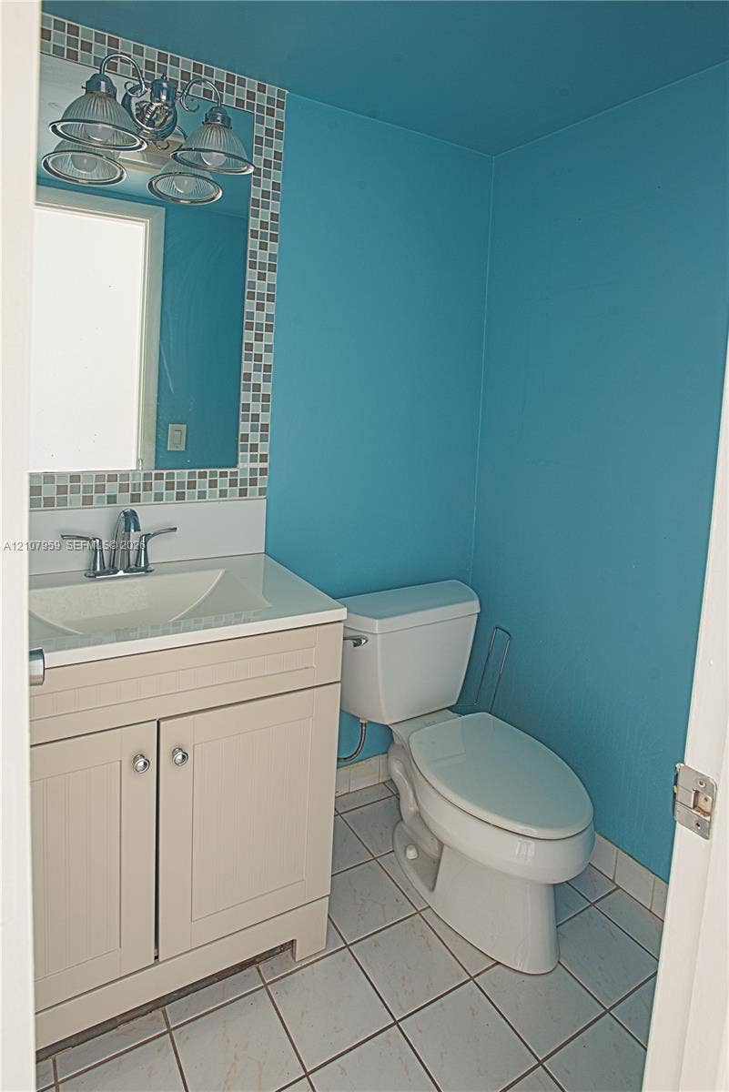 4200 Crystal Lake Drive, #204, Deerfield Beach, Deerfield Beach, FL 33064 Bathroom featuring a vanity with integrated sink, chrome dual-handle faucet, mosaic tile mirror border, and ceramic tile flooring