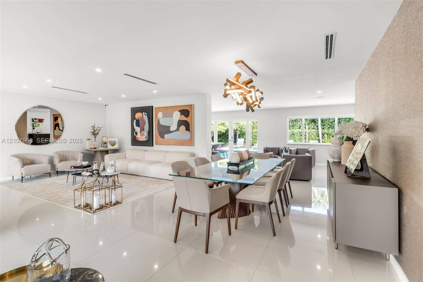 10841 SW 126th Street, Miami, FL 33176 Large-format white tile flooring, modern geometric chandelier, textured feature wall, and multi-panel glass garden doors