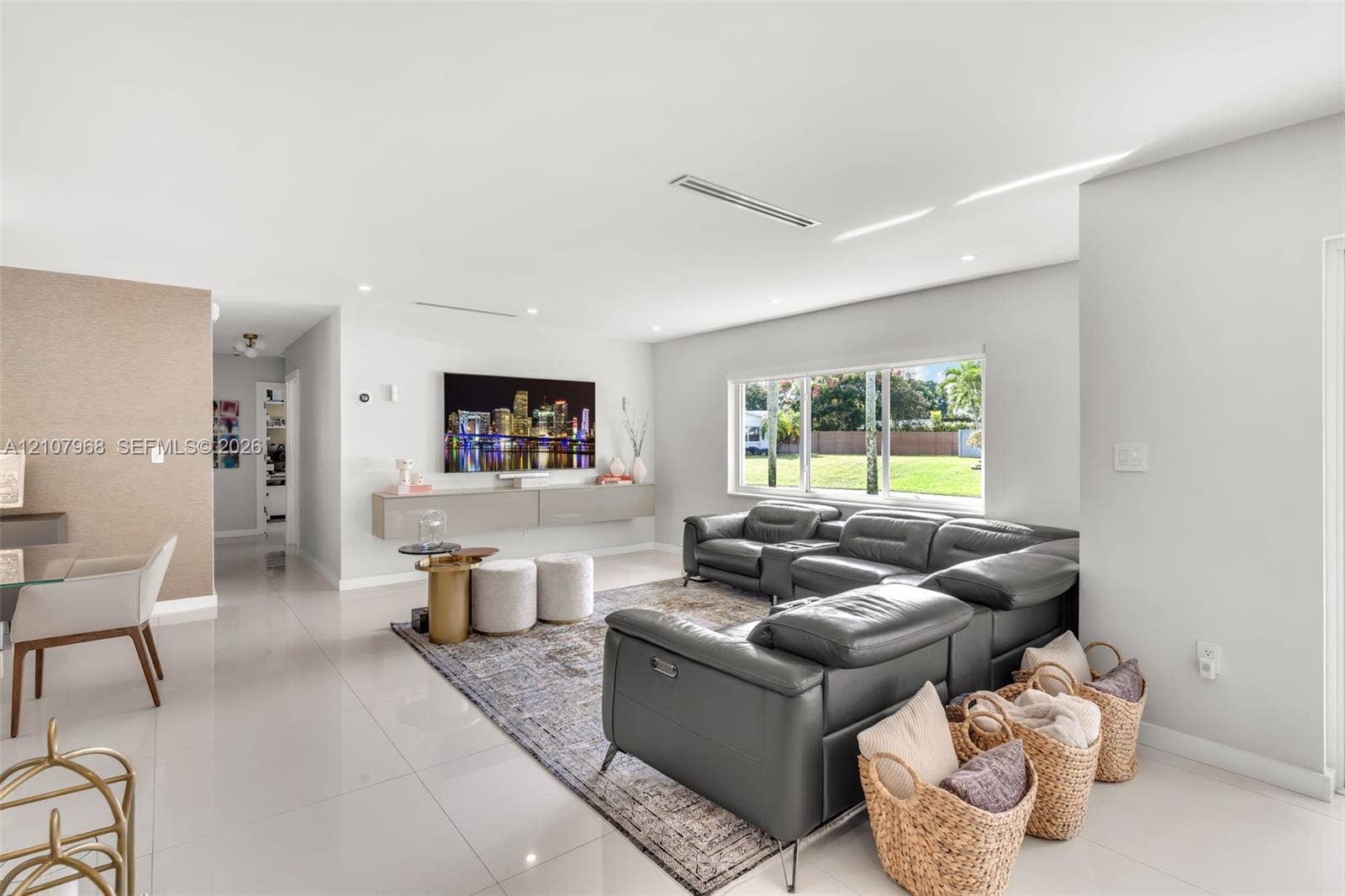 10841 SW 126th Street, Miami, FL 33176 Open-concept interior featuring large-format tile flooring, a wall-mounted floating media console, recessed lighting, and expansive windows