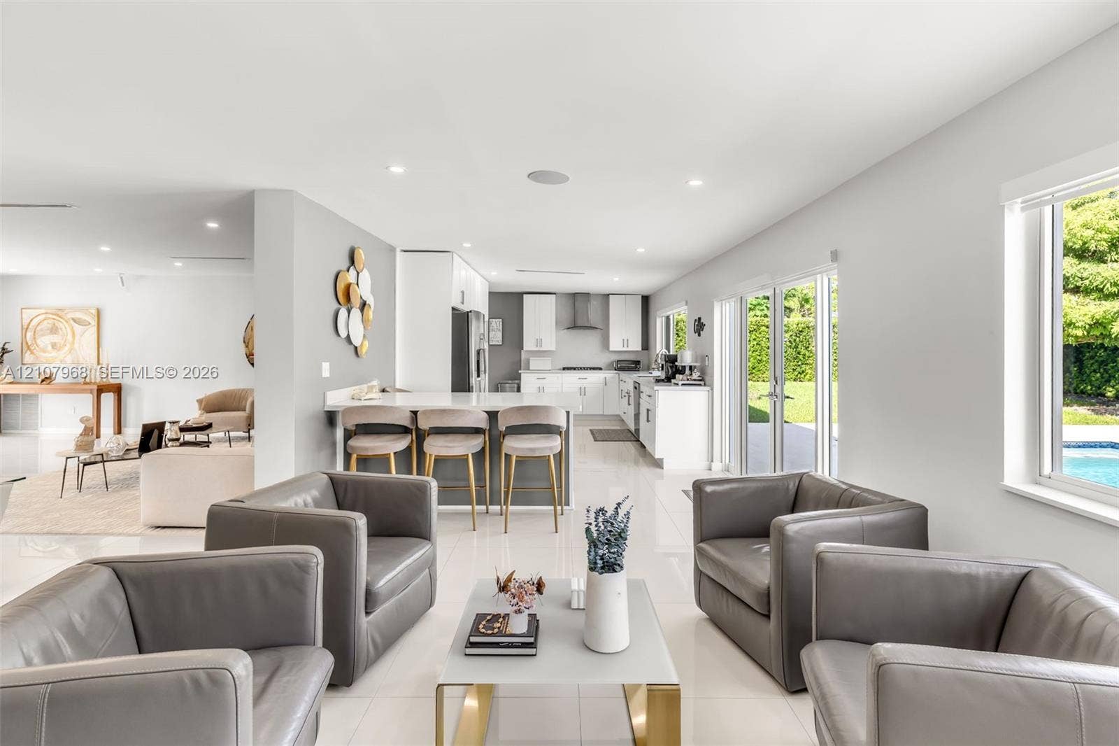 10841 SW 126th Street, Miami, FL 33176 Open-concept kitchen featuring white cabinetry, quartz countertops, a breakfast bar, recessed lighting, and large-format tile flooring