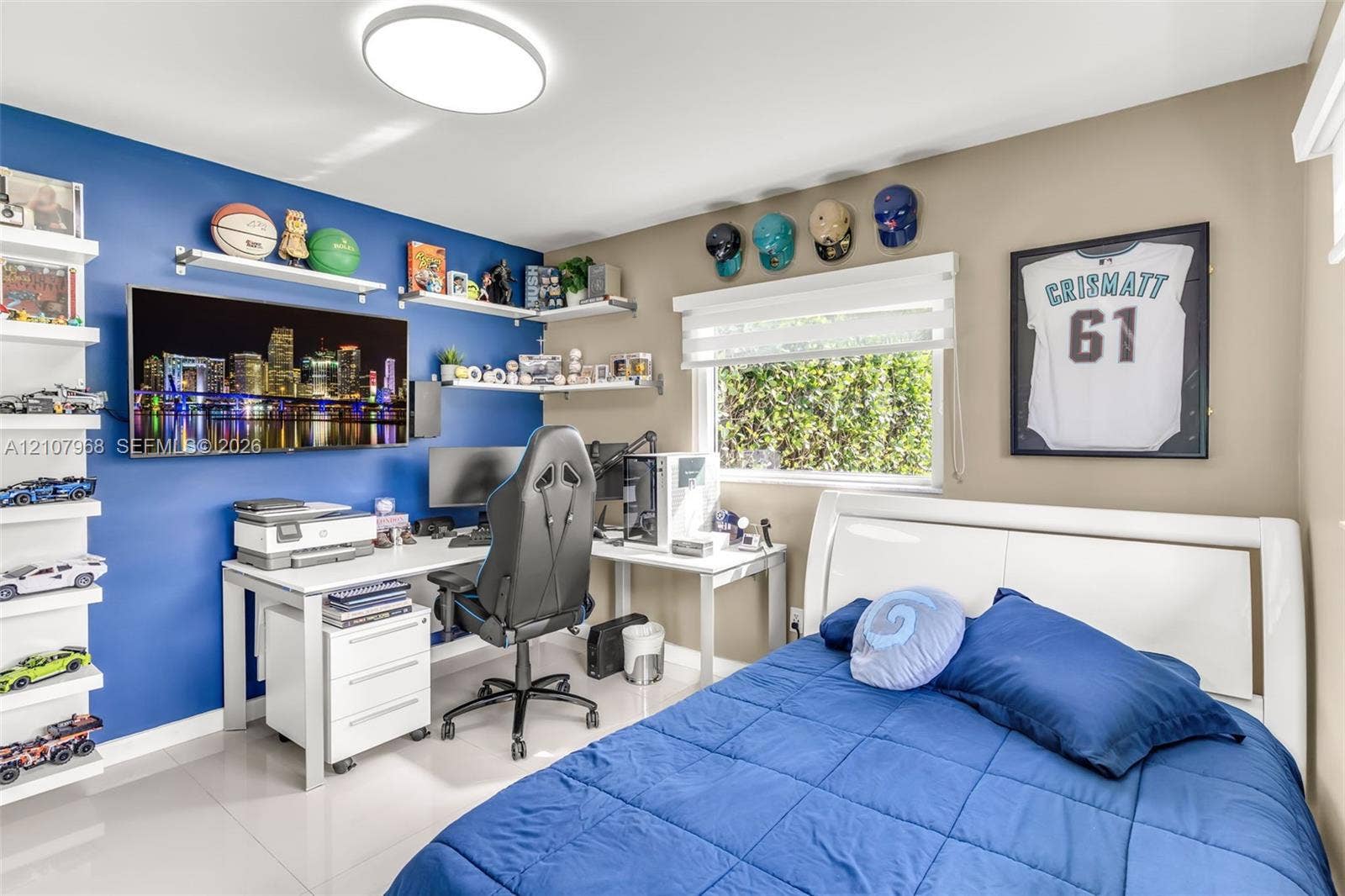 10841 SW 126th Street, Miami, FL 33176 Room featuring large-format tile flooring, multiple wall-mounted floating shelves, and a modern circular flush-mount ceiling light