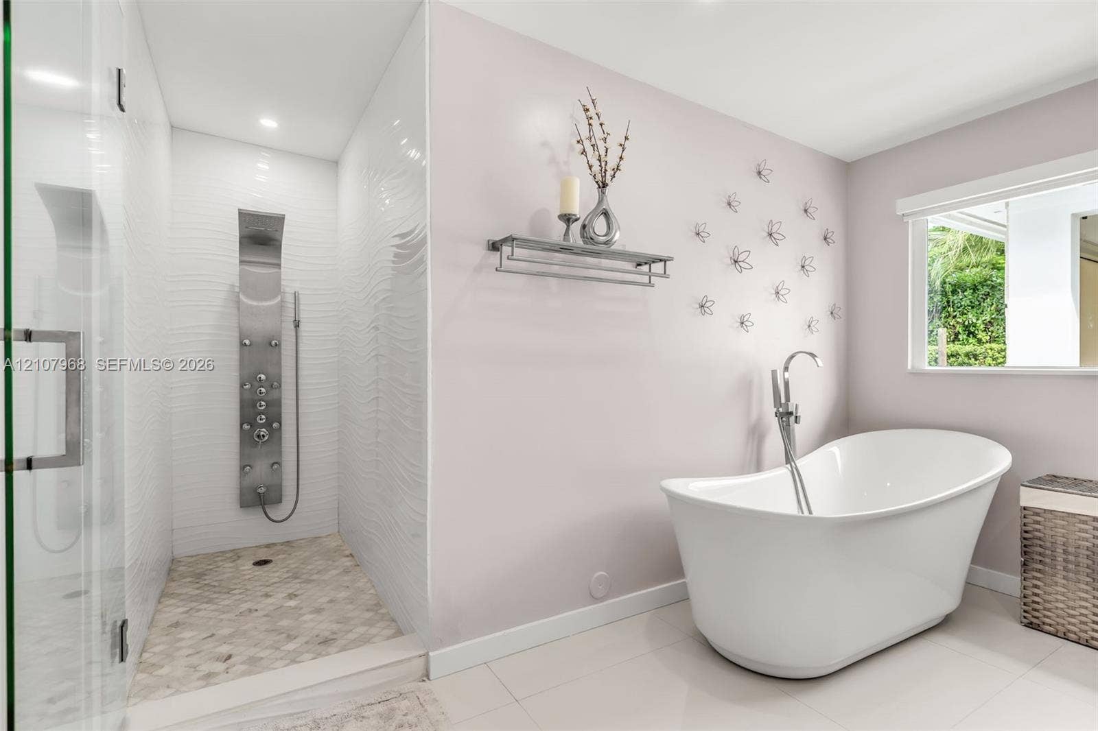 10841 SW 126th Street, Miami, FL 33176 Freestanding soaking tub with a floor-mounted faucet, walk-in shower featuring textured wall tile, stainless steel rainfall shower panel, and pebble-style shower flooring