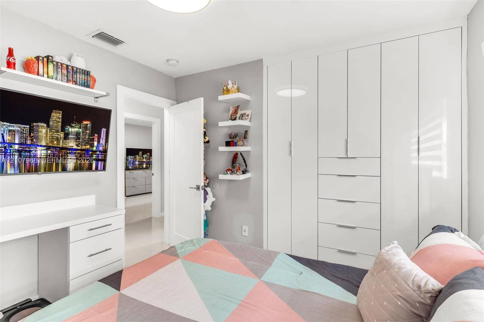 10841 SW 126th Street, Miami, FL 33176 Floor-to-ceiling white cabinetry featuring integrated drawer storage, built-in white desk with drawer storage, and wall-mounted white shelving