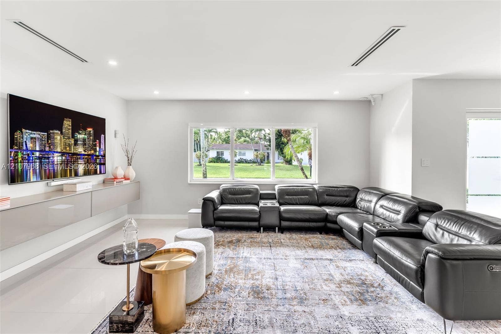 10841 SW 126th Street, Miami, FL 33176 Living area featuring large-format tile flooring, recessed ceiling lighting, and a wall-mounted floating cabinetry unit