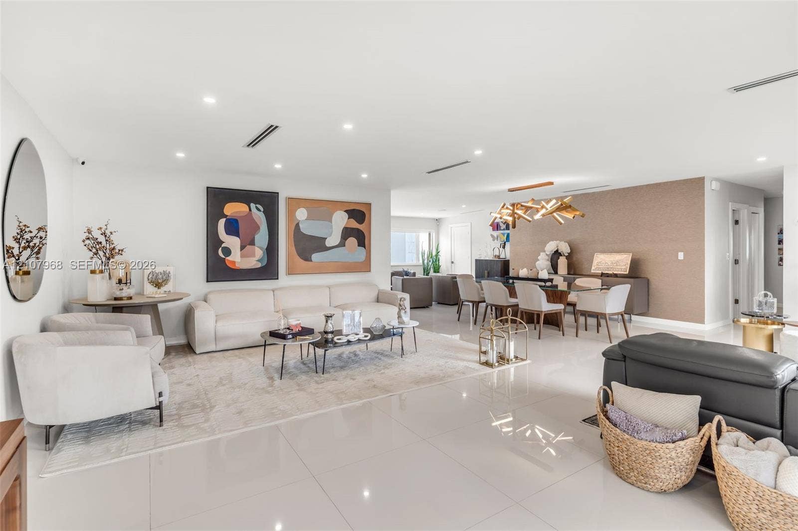 10841 SW 126th Street, Miami, FL 33176 Open-concept interior featuring large-format tile flooring, recessed ceiling lighting, textured accent wall, and a contemporary multi-arm chandelier