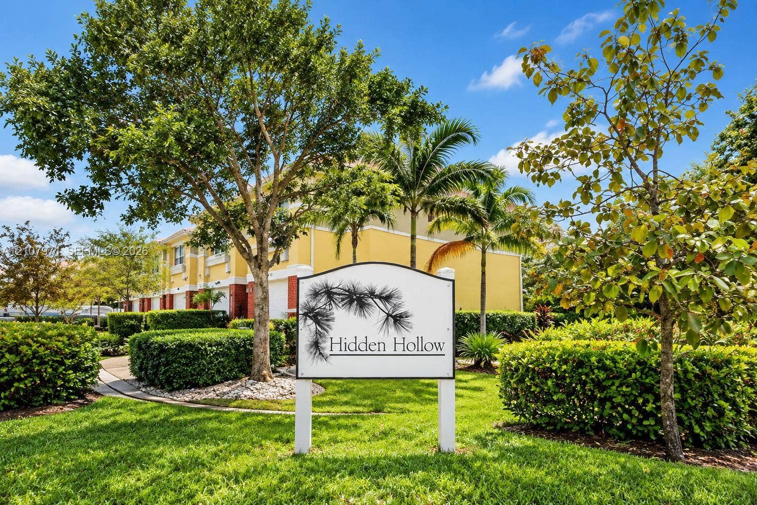 4921 SW 66th Terrace, #4921, Davie, Davie, FL 33314 Community entrance sign featuring professional signage, manicured landscaping, mature trees, palm trees, and paved walkways