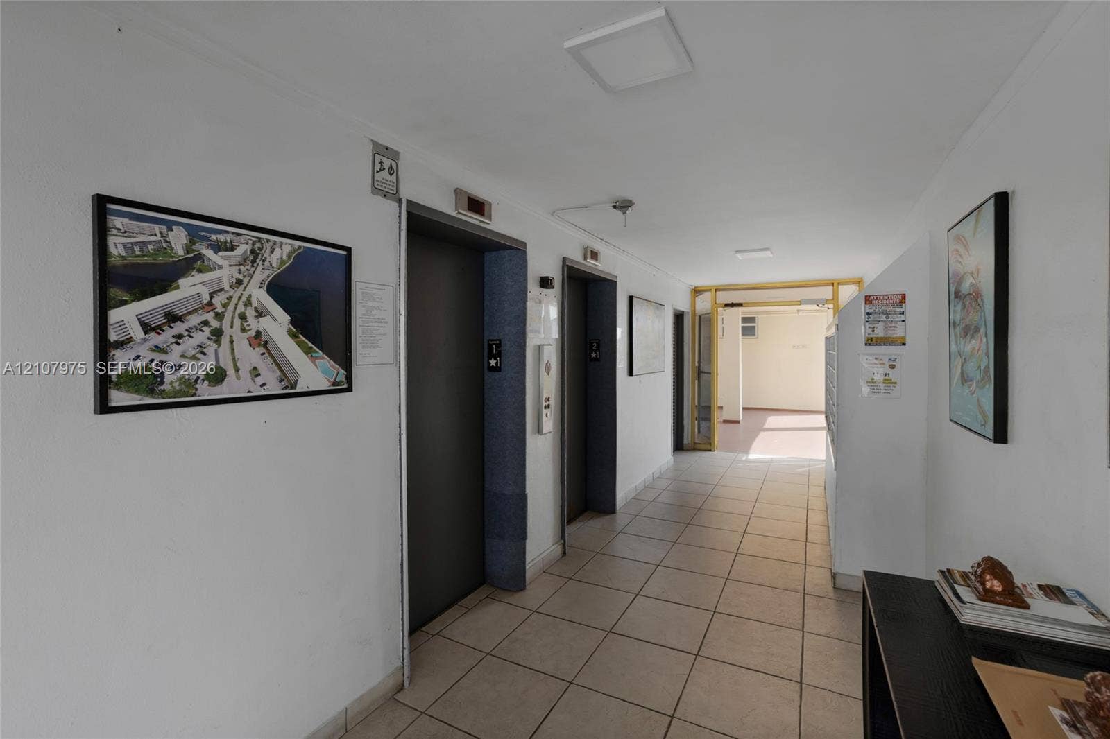 2910 Point East Drive, #M108, Aventura, FL 33160 Building lobby area featuring dual elevators, ceramic tile flooring, and integrated mailboxes