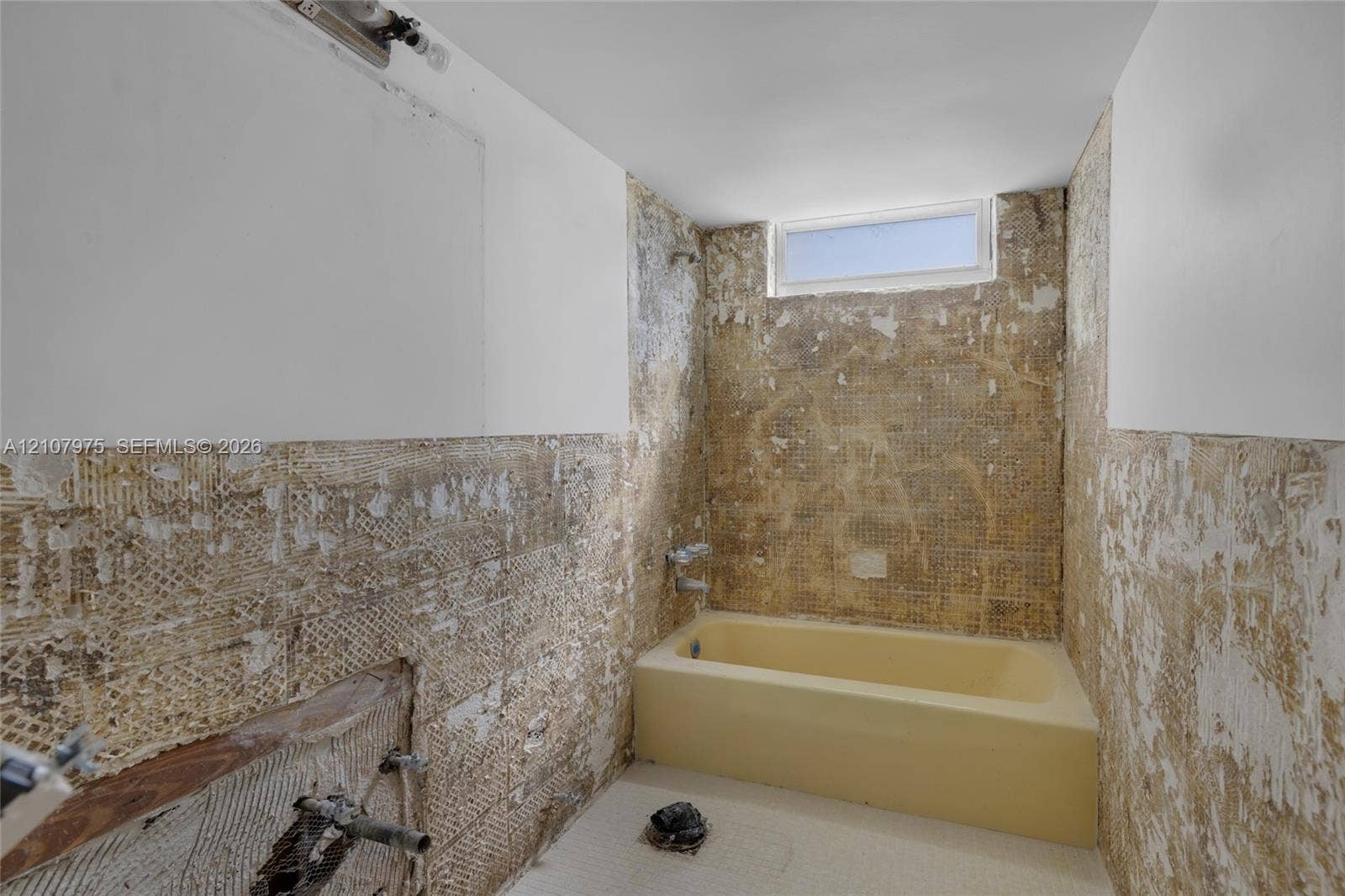 2910 Point East Drive, #M108, Aventura, FL 33160 Bathroom featuring an alcove bathtub with chrome fixtures and a transom window