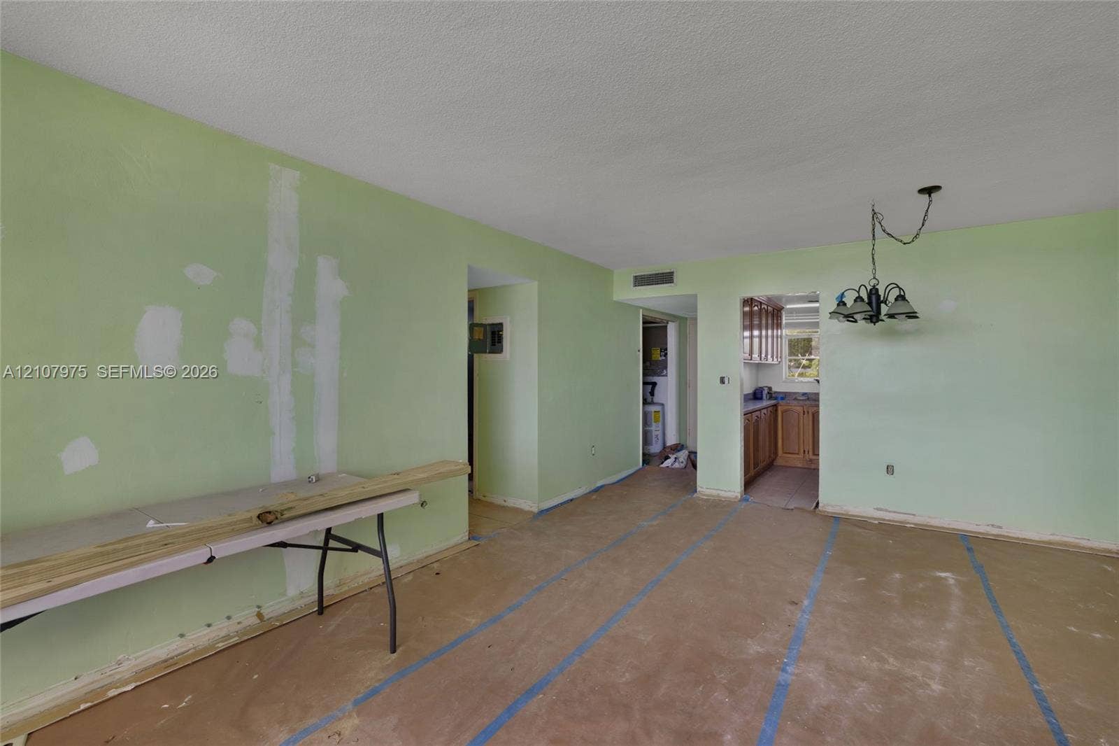 2910 Point East Drive, #M108, Aventura, FL 33160 Interior space featuring a multi-arm hanging light fixture and access to an enclosed kitchen area