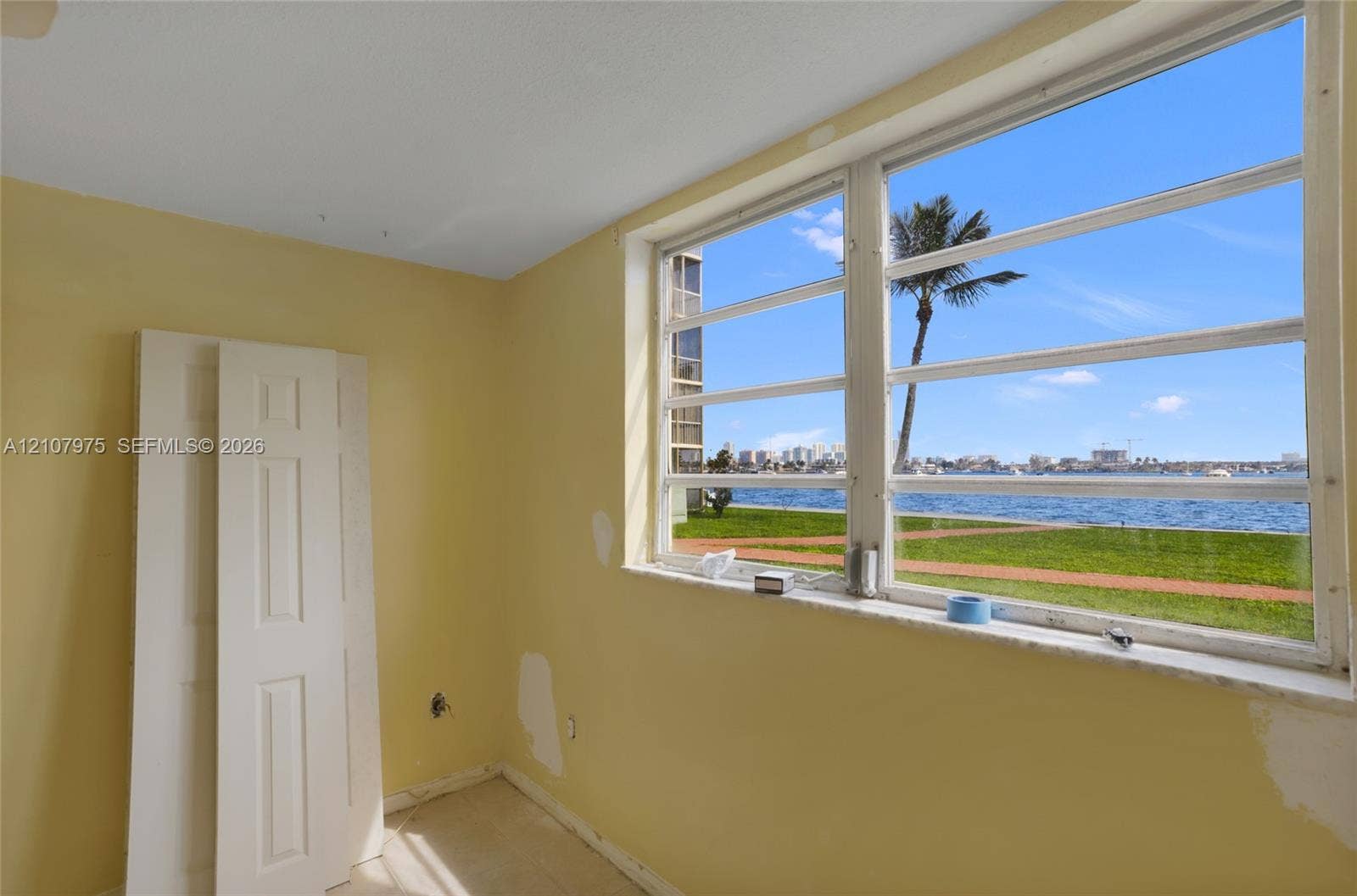 2910 Point East Drive, #M108, Aventura, FL 33160 Large multi-pane window with waterfront and landscape scenery