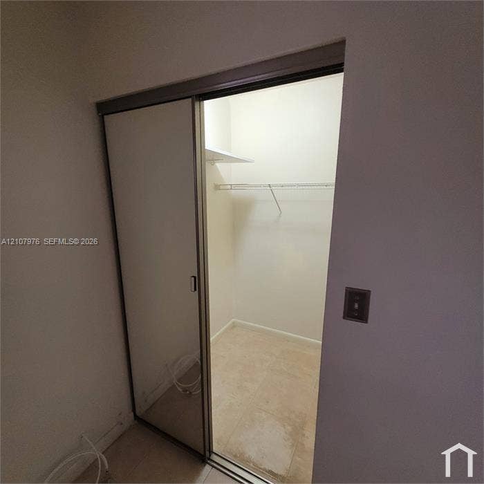 5100 SW 41st Street, #101, Hollywood, Hollywood, FL 33023 Closet featuring sliding mirror doors, metal wire shelving, and tile flooring