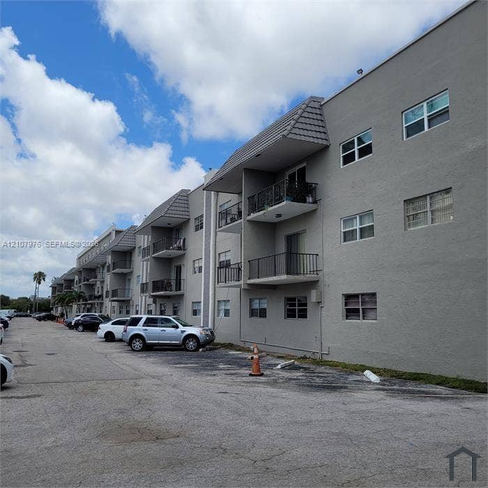 5100 SW 41st Street, #101, Hollywood, Hollywood, FL 33023 Multi-story stucco exterior featuring stacked metal-railed balconies and tiled roof accents