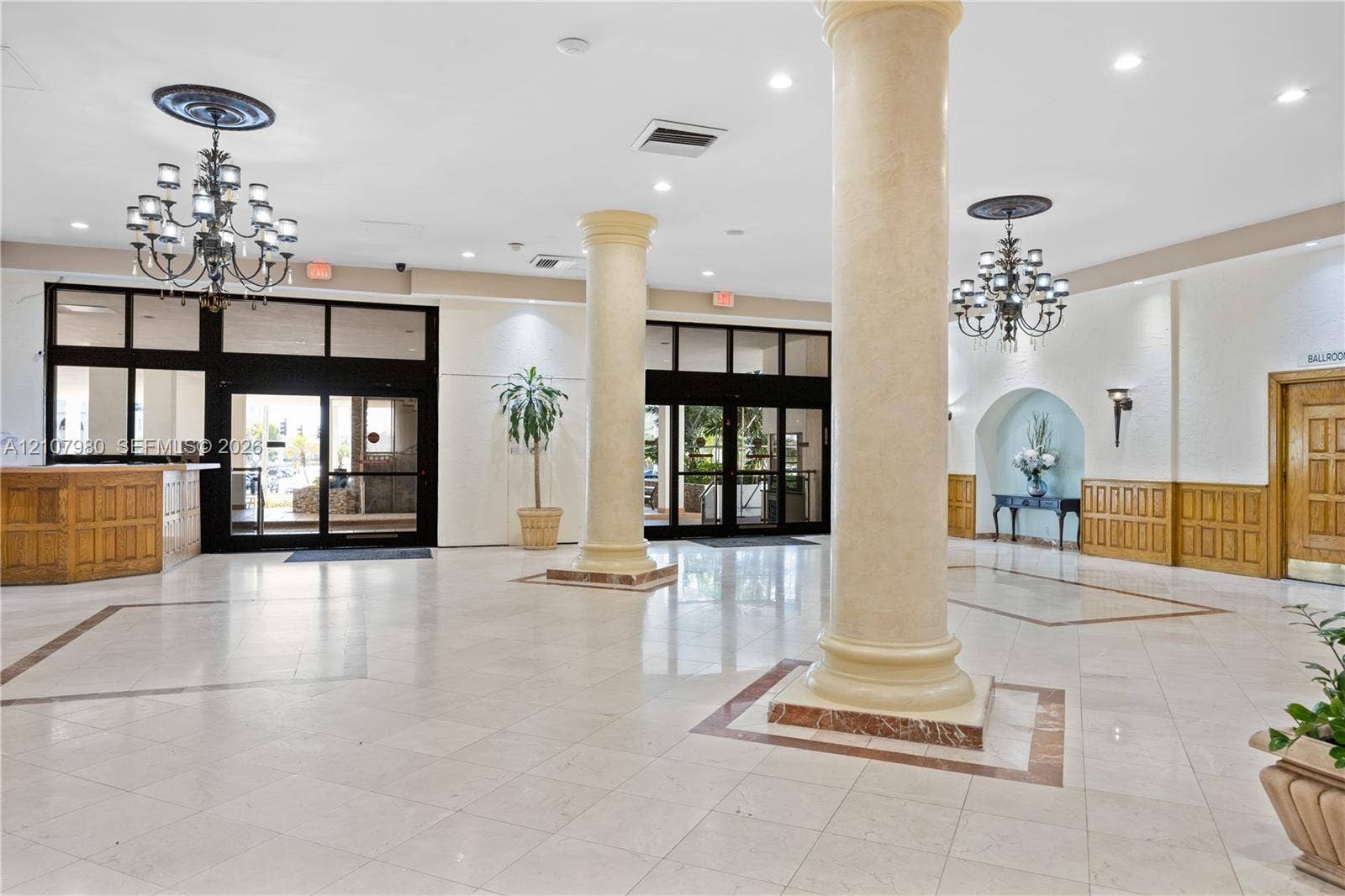 3725 S Ocean Drive, #1120, Hollywood, Hollywood, FL 33019 Grand foyer featuring tile flooring, structural columns, ornate chandeliers, recessed lighting, and wood-paneled accents