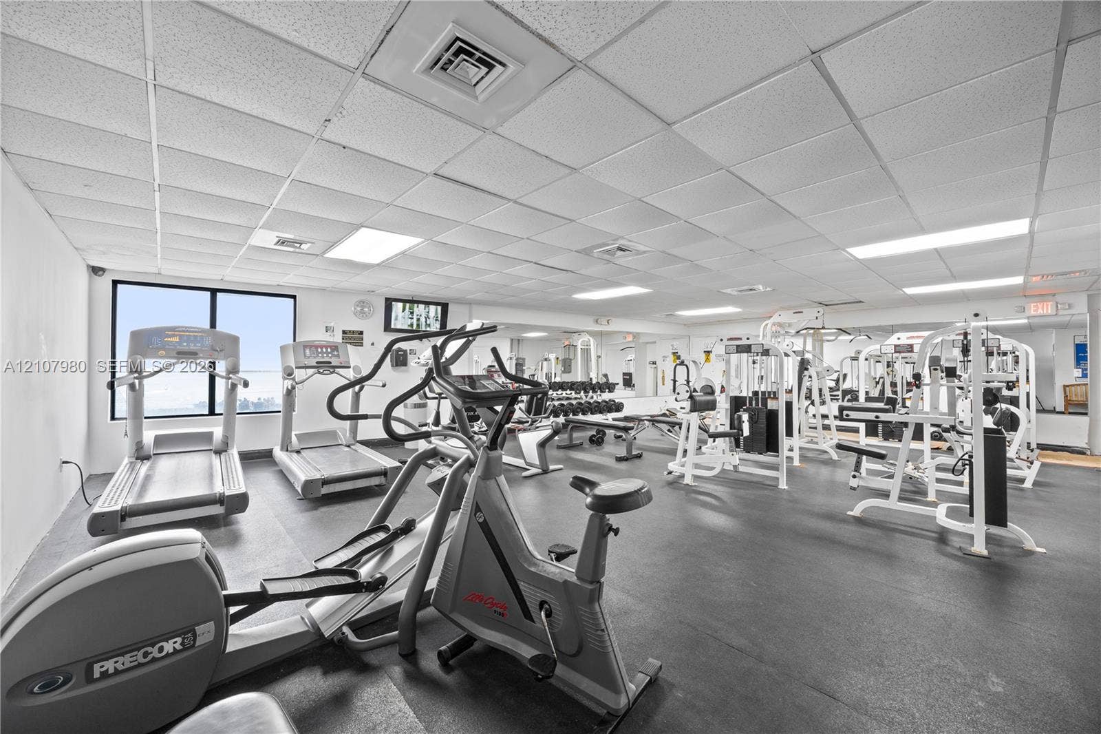 3725 S Ocean Drive, #1120, Hollywood, Hollywood, FL 33019 Fitness center featuring rubber flooring, drop ceiling with recessed lighting, and wall-to-wall mirrors