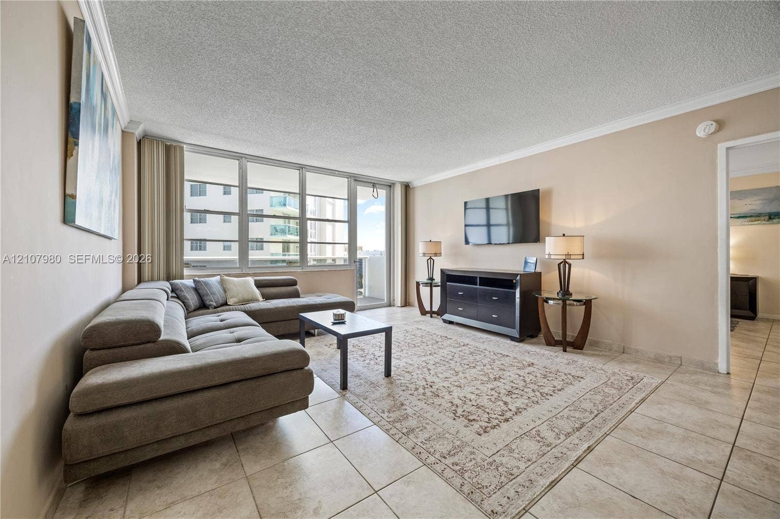 3725 S Ocean Drive, #1120, Hollywood, Hollywood, FL 33019 Living area featuring tile flooring, crown molding, and floor-to-ceiling windows with integrated sliding glass door