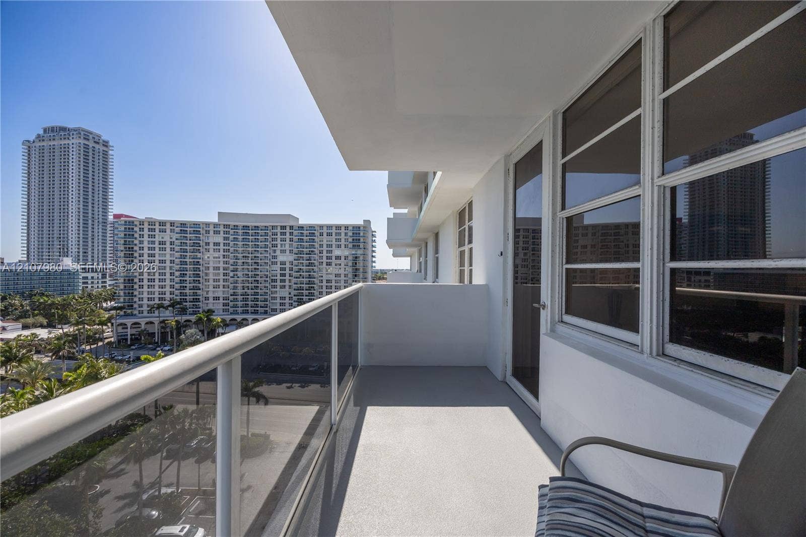 3725 S Ocean Drive, #1120, Hollywood, Hollywood, FL 33019 Private covered balcony featuring a glass and metal railing, concrete flooring, and large windowed exterior wall