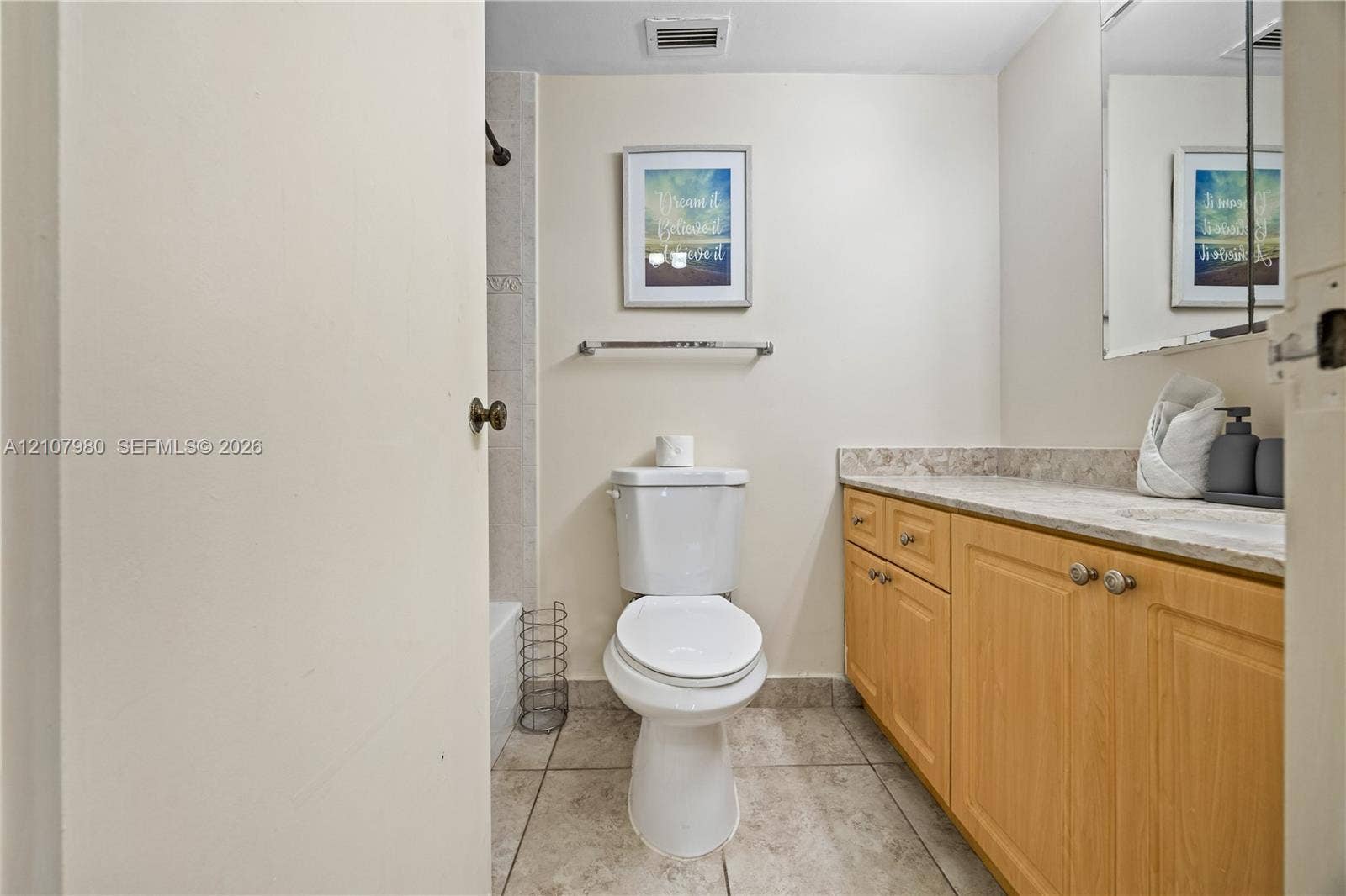 3725 S Ocean Drive, #1120, Hollywood, Hollywood, FL 33019 Bathroom featuring light wood-finish cabinetry, stone-style countertop, tile flooring, and a wall-mounted mirror