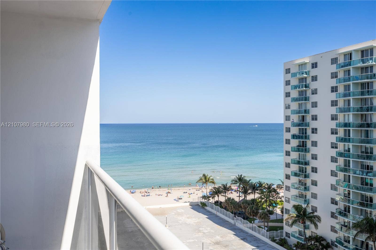 3725 S Ocean Drive, #1120, Hollywood, Hollywood, FL 33019 Private balcony with white metal railings, oriented toward an expansive ocean horizon and sandy shoreline