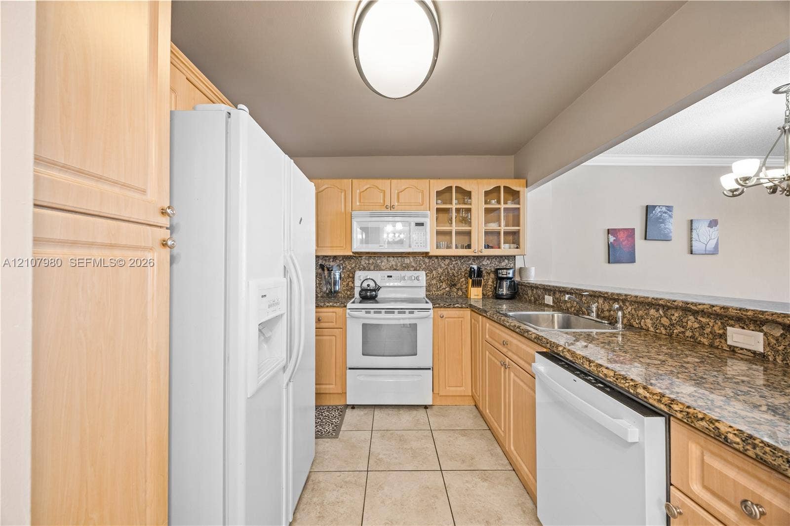 3725 S Ocean Drive, #1120, Hollywood, Hollywood, FL 33019 Kitchen featuring light-finish cabinetry, stone-finish countertops, ceramic tile flooring, built-in glass-front upper cabinets, and a pass-through opening