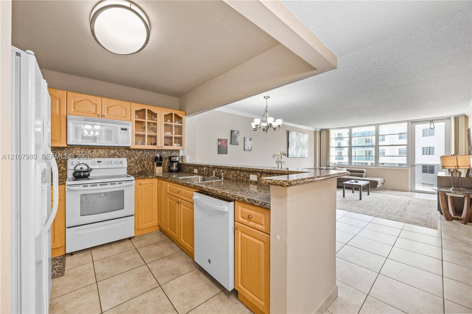 3725 S Ocean Drive, #1120, Hollywood, Hollywood, FL 33019 Kitchen featuring natural finish cabinetry, stone-style countertops, white appliances, and tiled flooring