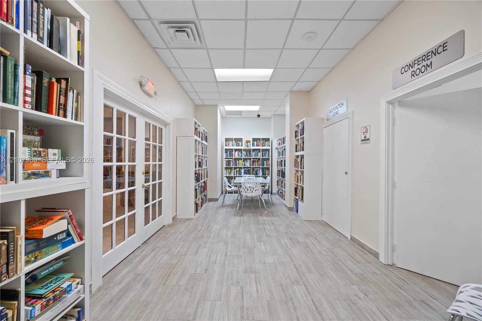 3725 S Ocean Drive, #1120, Hollywood, Hollywood, FL 33019 Interior hallway featuring wood-finish flooring, drop ceiling with recessed lighting, and multiple floor-to-ceiling built-in white shelving units