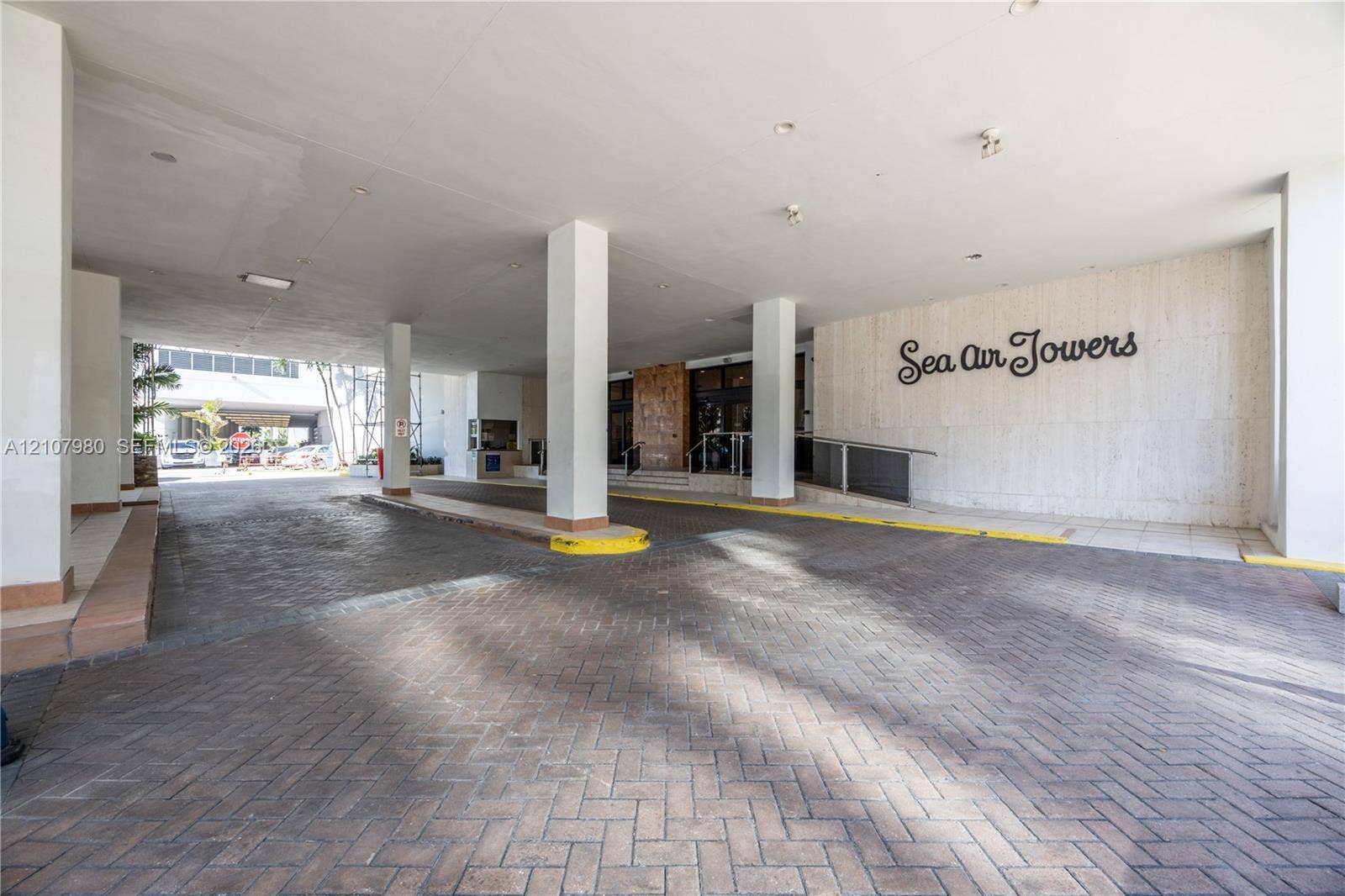 3725 S Ocean Drive, #1120, Hollywood, Hollywood, FL 33019 Covered porte-cochere entrance featuring a brick-paver driveway, structural support columns, and recessed ceiling lighting