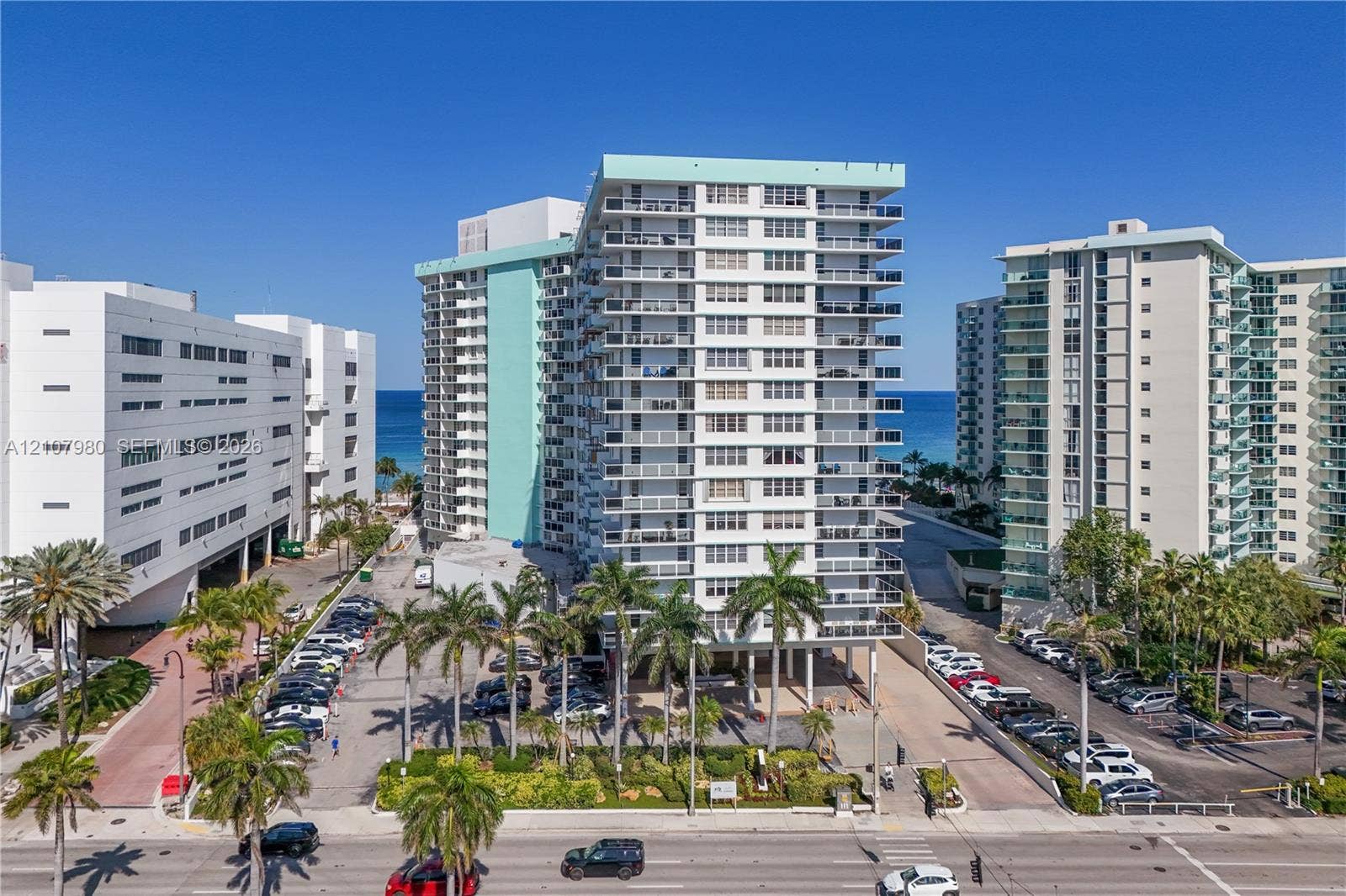 3725 S Ocean Drive, #1120, Hollywood, Hollywood, FL 33019 High-rise multi-story building featuring private balconies, floor-to-ceiling glass doors, and mature palm tree landscaping