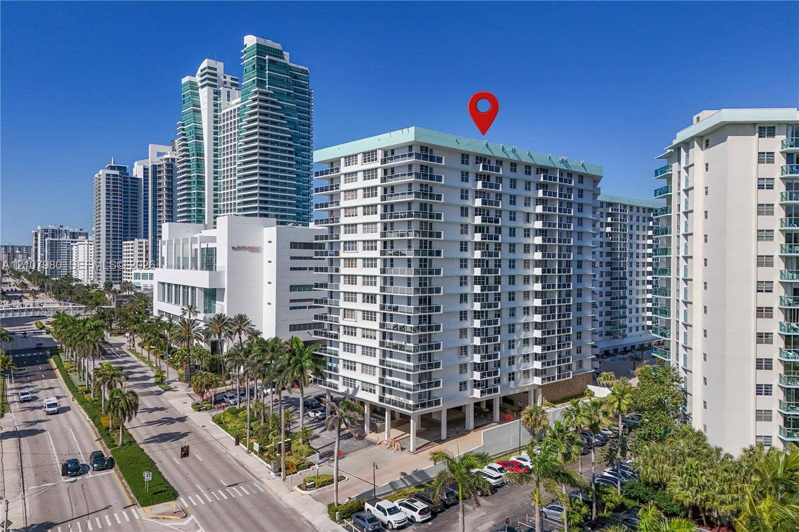 3725 S Ocean Drive, #1120, Hollywood, Hollywood, FL 33019 High-rise residential building featuring private balconies, floor-to-ceiling glass doors, and covered ground-level parking