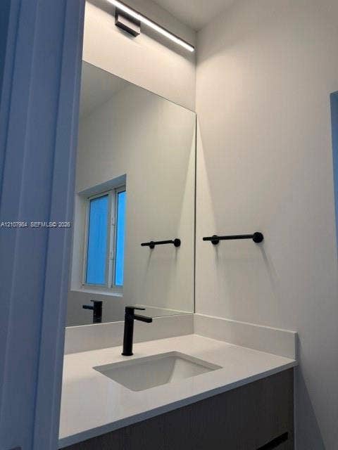 1567 NW 94th Way, #10, Coral Springs, Coral Springs, FL 33071 Wall-mounted linear LED lighting, large-format mirror, matte black faucet, integrated basin, and white solid-surface countertop