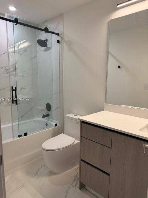 1567 NW 94th Way, #10, Coral Springs, Coral Springs, FL 33071 Bathroom featuring a sliding glass shower door with matte black hardware, rainfall showerhead, large-format tile flooring, vanity with a light-tone wood-finish cabinet, and a solid surface countertop