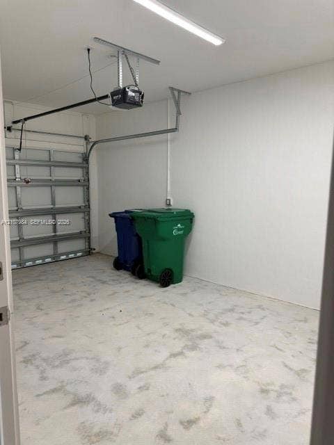 1567 NW 94th Way, #10, Coral Springs, Coral Springs, FL 33071 Garage featuring a concrete floor, finished interior walls, an automated door opener, and overhead LED lighting