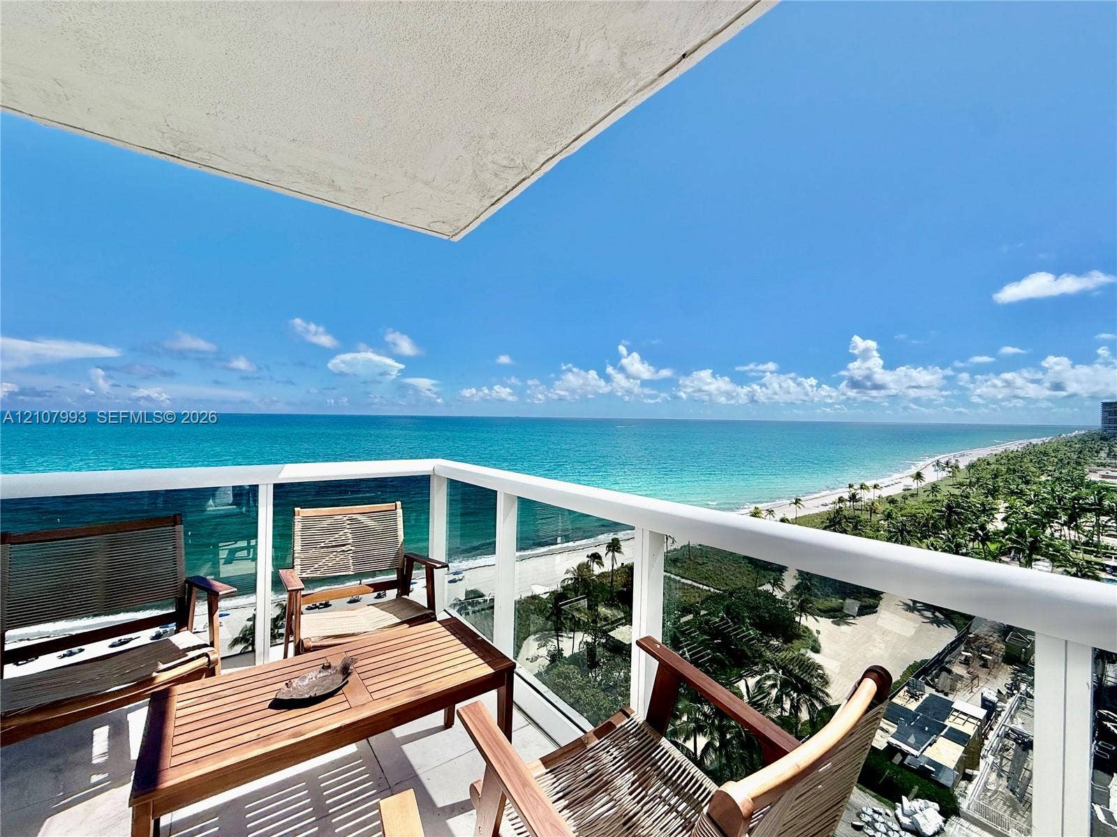 10275 Collins Avenue, #1110, Bal Harbour, Bal Harbour, FL 33154 Private balcony featuring a glass-panel railing, overhead covering, and concrete flooring, overlooking the coastline and ocean