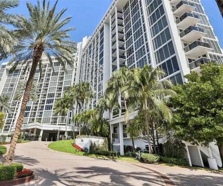 10275 Collins Avenue, #1110, Bal Harbour, Bal Harbour, FL 33154 High-rise architectural exterior featuring glass curtain walls, private balconies, a porte-cochre entry, and mature landscaping