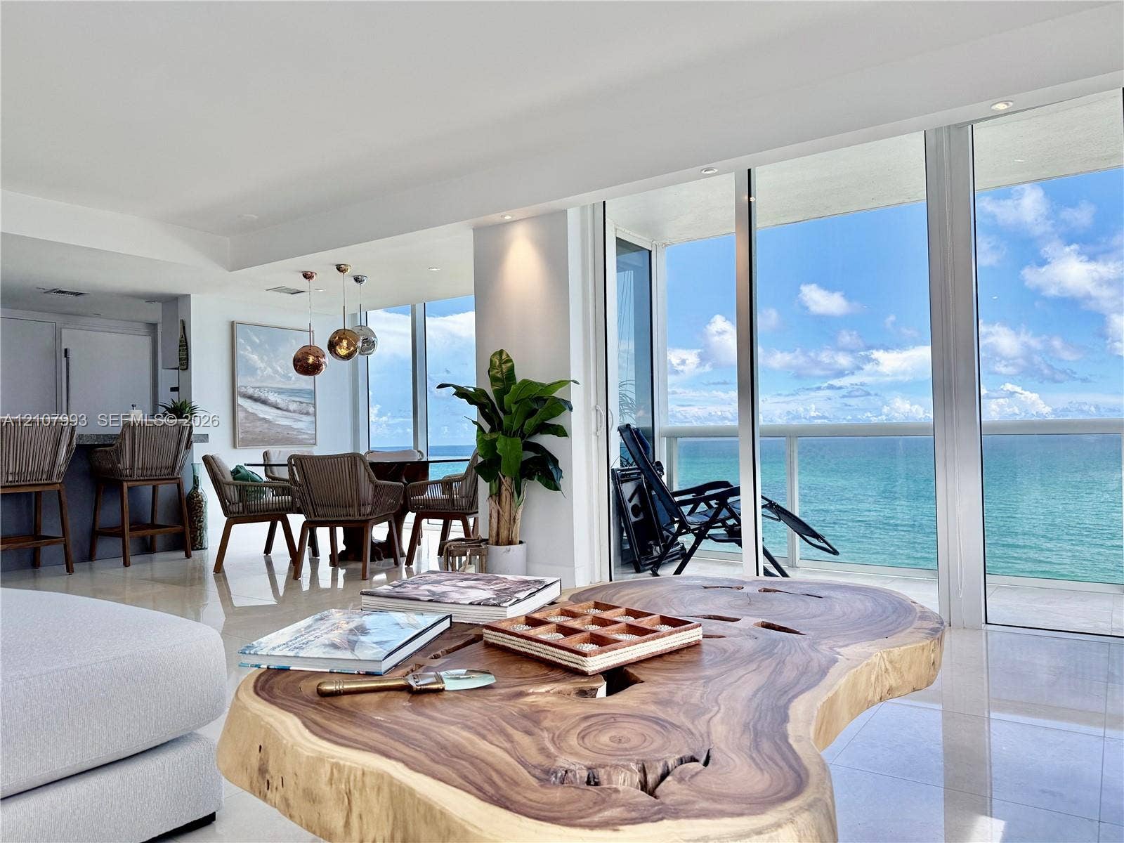 10275 Collins Avenue, #1110, Bal Harbour, Bal Harbour, FL 33154 Floor-to-ceiling glass panel walls, polished tile flooring, recessed ceiling lighting, built-in kitchen cabinetry, and an attached balcony overlooking the ocean