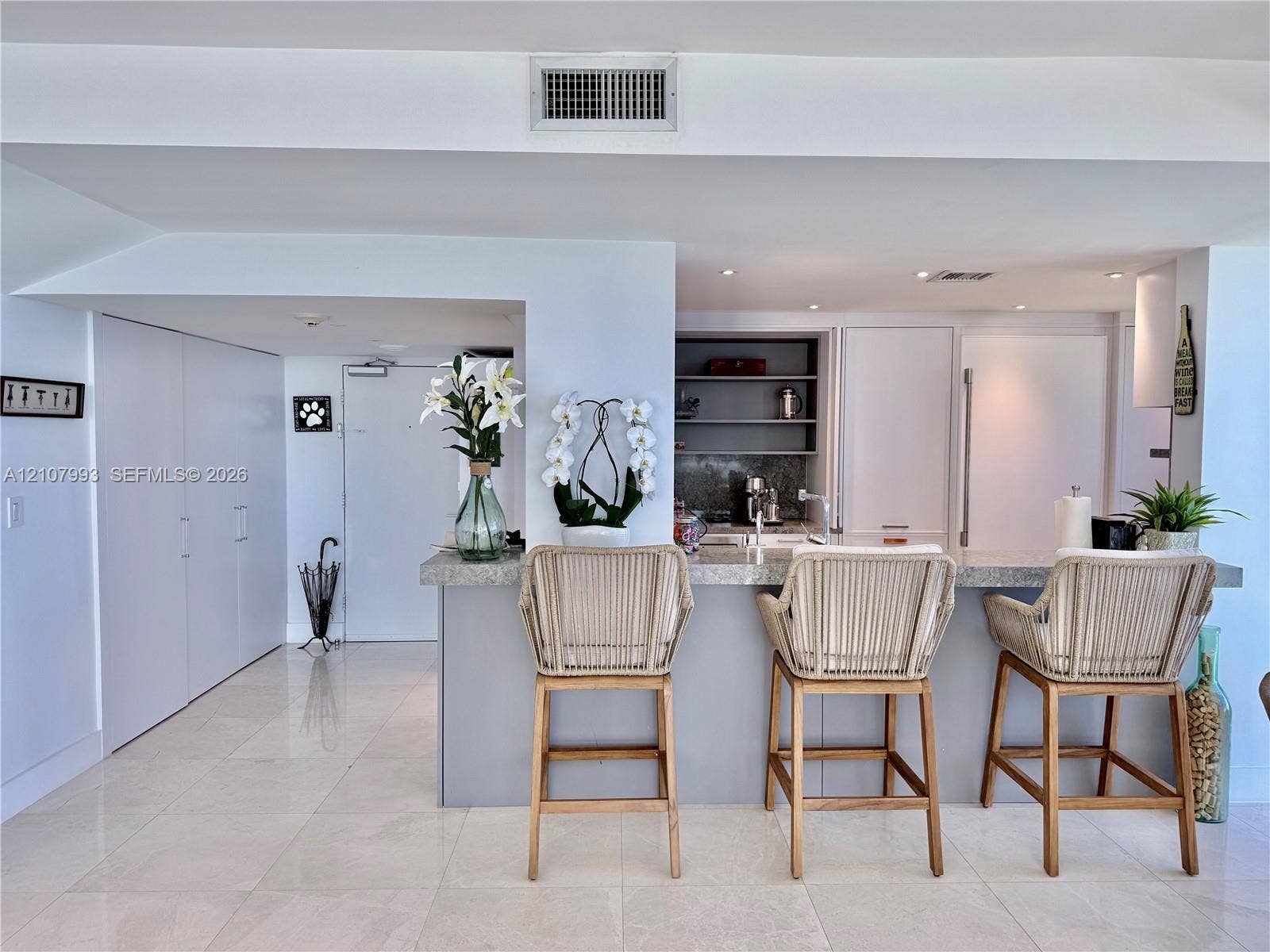 10275 Collins Avenue, #1110, Bal Harbour, Bal Harbour, FL 33154 Kitchen featuring a stone-topped breakfast bar, recessed ceiling lighting, built-in cabinetry, and tile flooring