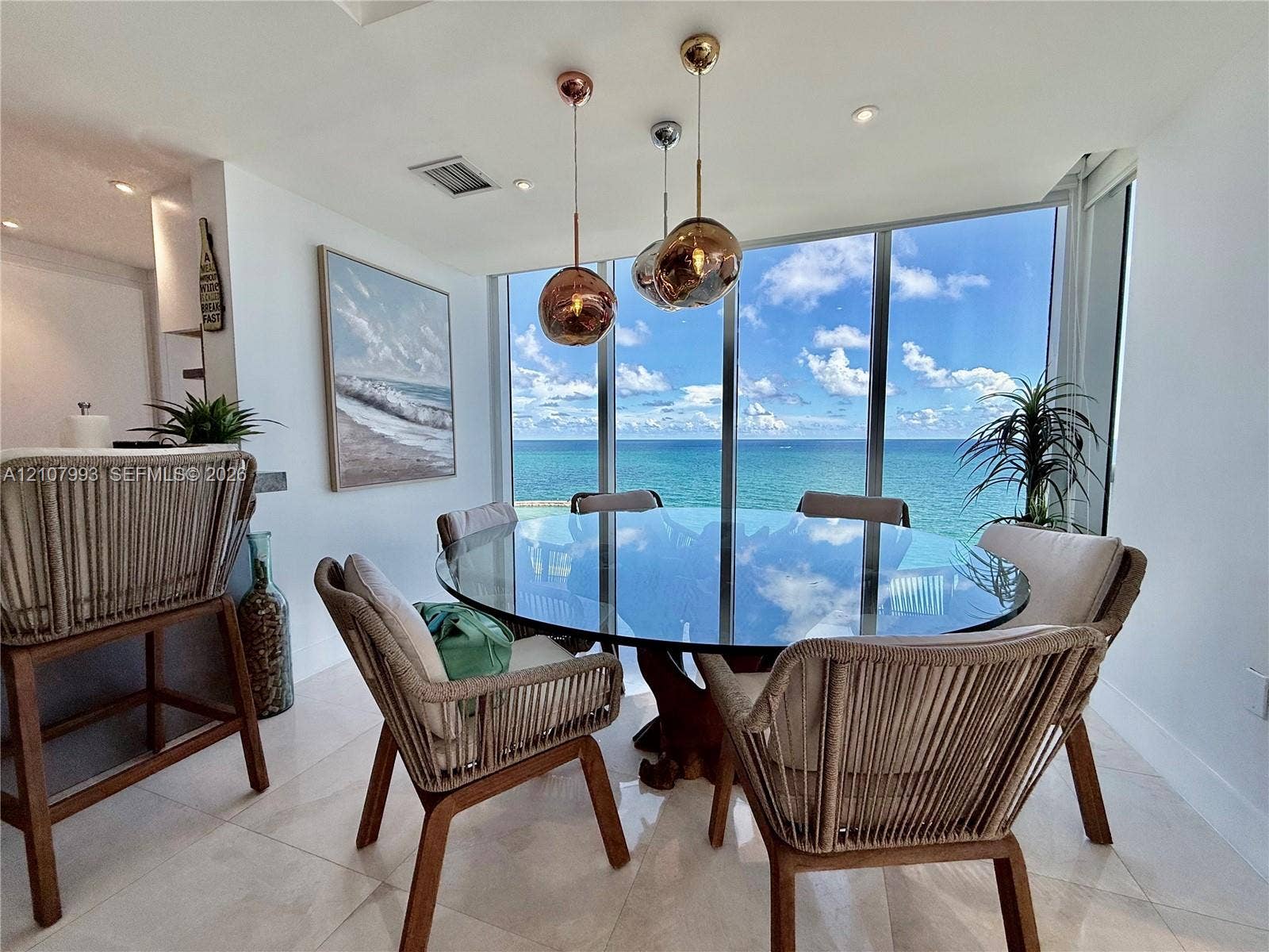 10275 Collins Avenue, #1110, Bal Harbour, Bal Harbour, FL 33154 Floor-to-ceiling windows featuring ocean scenery, large-format tile flooring, and metallic spherical pendant lighting