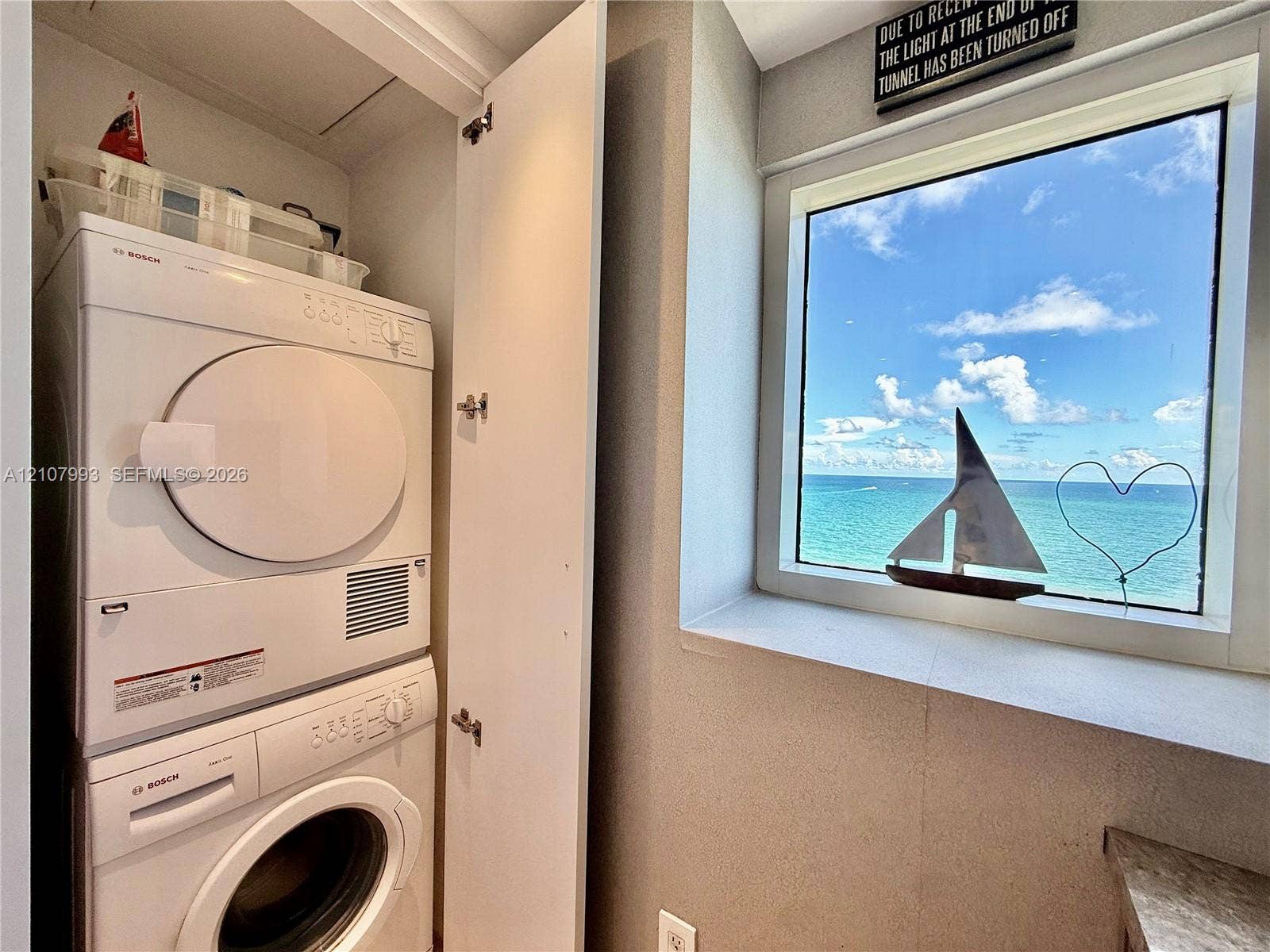 10275 Collins Avenue, #1110, Bal Harbour, Bal Harbour, FL 33154 Stacked Bosch laundry center with a single-pane window featuring expansive ocean scenery