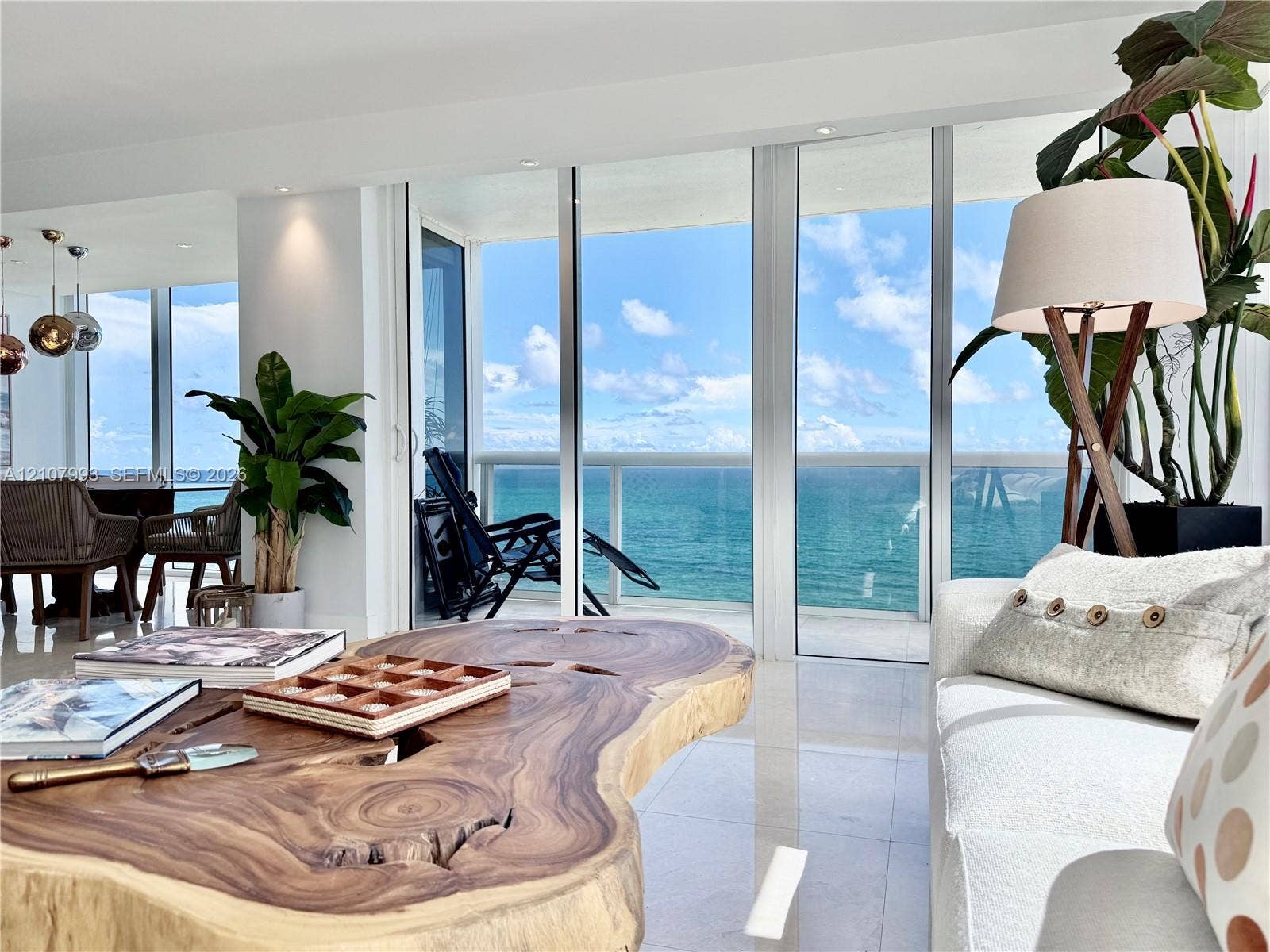 10275 Collins Avenue, #1110, Bal Harbour, Bal Harbour, FL 33154 Floor-to-ceiling glass panel walls, light-reflective stone flooring, recessed ceiling lighting, and a glass-railed balcony overlooking the ocean