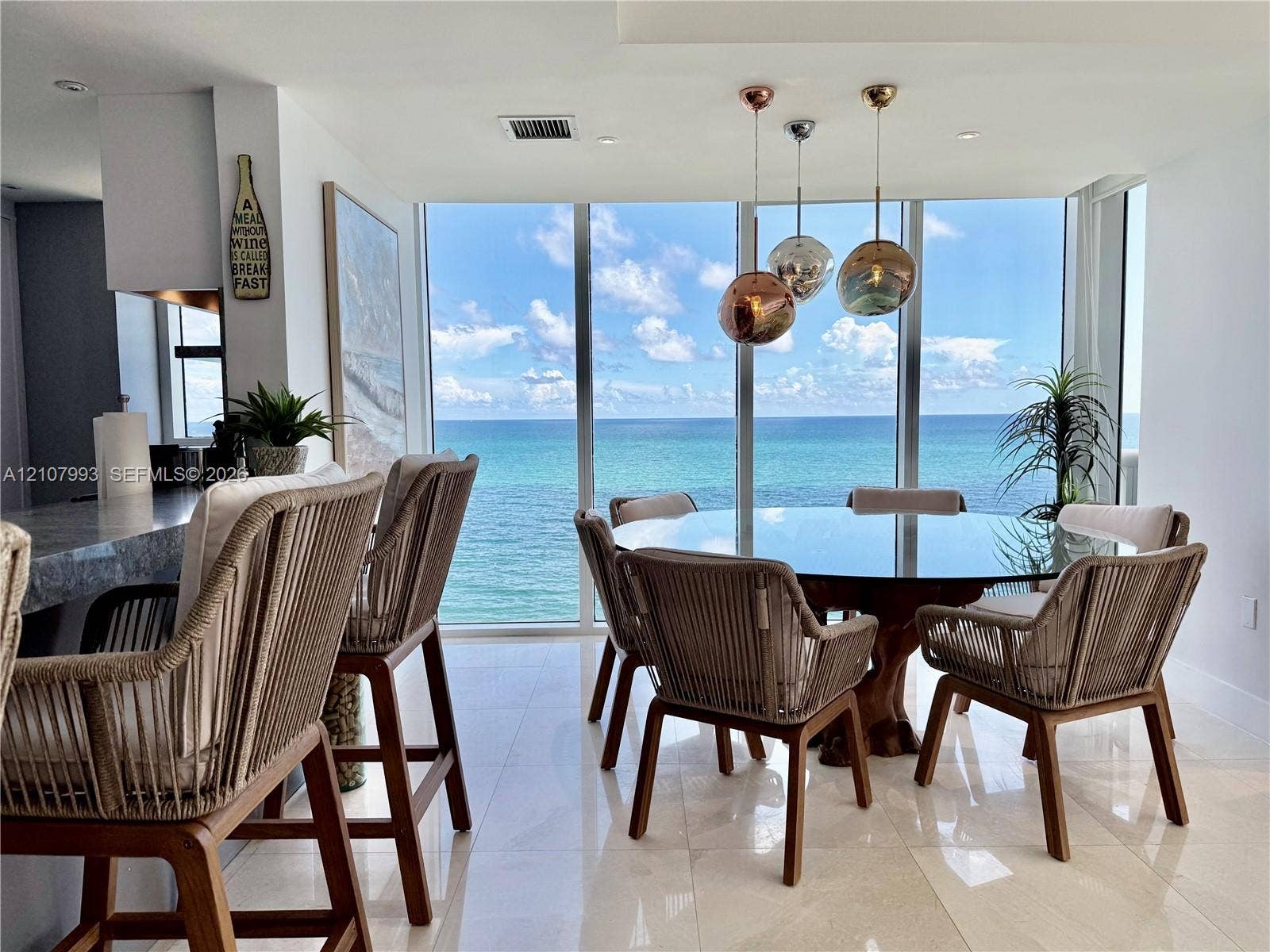 10275 Collins Avenue, #1110, Bal Harbour, Bal Harbour, FL 33154 Floor-to-ceiling windows with ocean backdrop, polished stone flooring, and trio of spherical pendant light fixtures