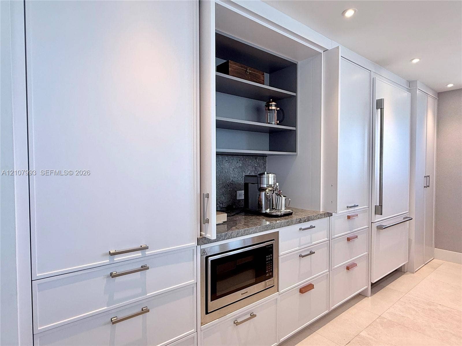 10275 Collins Avenue, #1110, Bal Harbour, Bal Harbour, FL 33154 Floor-to-ceiling cabinetry with custom millwork, integrated refrigerator, stone countertop, built-in microwave, and recessed lighting