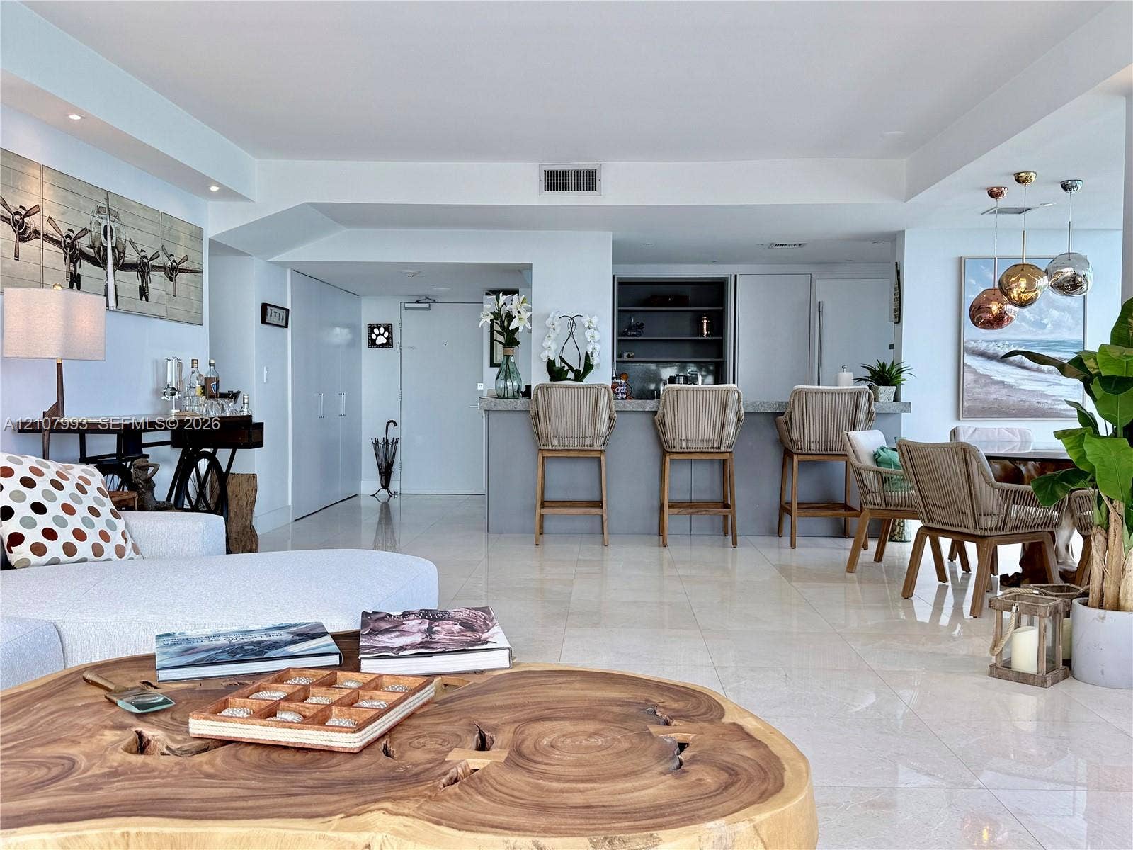 10275 Collins Avenue, #1110, Bal Harbour, Bal Harbour, FL 33154 Open-concept living area featuring large-format tile flooring, a built-in kitchen bar with stone countertop, recessed lighting, and sleek custom cabinetry
