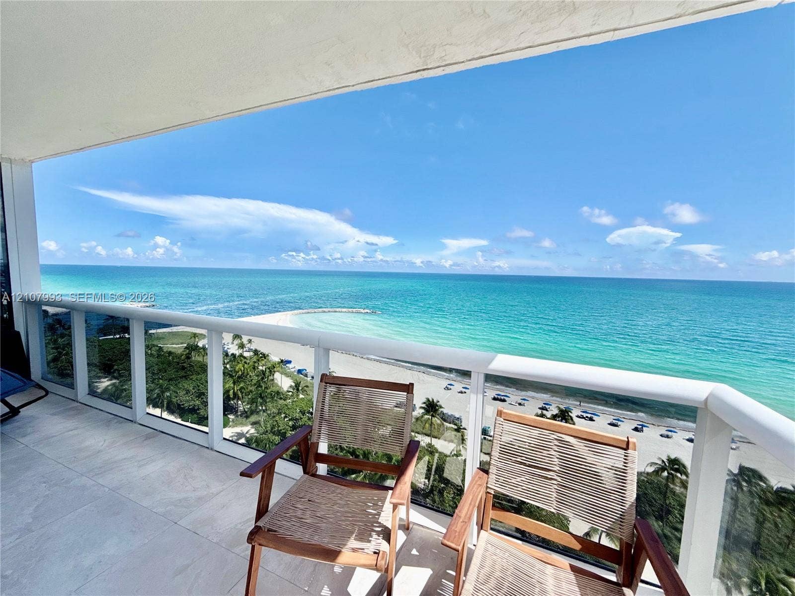 10275 Collins Avenue, #1110, Bal Harbour, Bal Harbour, FL 33154 Covered balcony featuring oversized neutral floor tiling and white-framed glass panel railings with an open-air oceanfront exposure