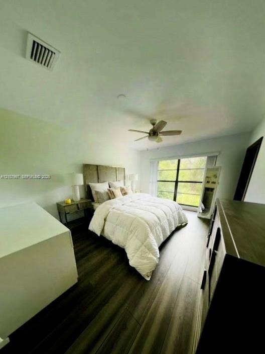 6814 SW 114th Place, #G65, Miami, FL 33173 Master bedroom featuring wood-finish flooring, a ceiling fan with integrated lighting, floor to ceiling windows. Bed linen is virtually staged.