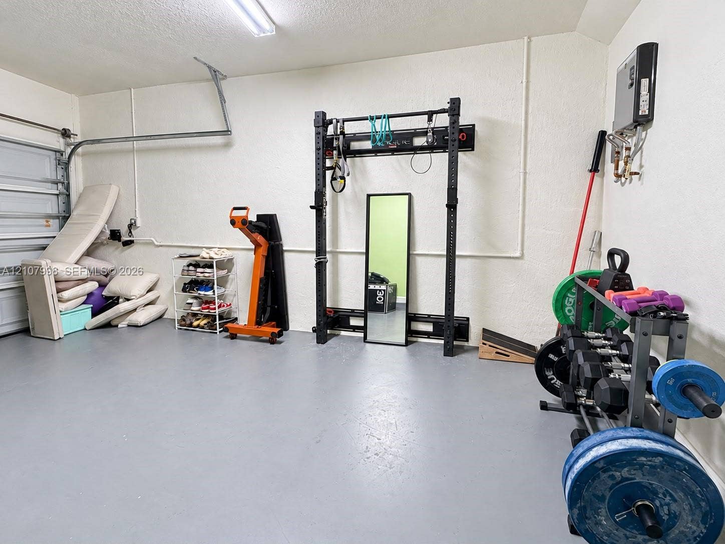 23471 SW 129th Avenue, Homestead, Homestead, FL 33032 Multi-purpose garage space featuring painted concrete flooring, wall-mounted steel structure, and overhead LED lighting