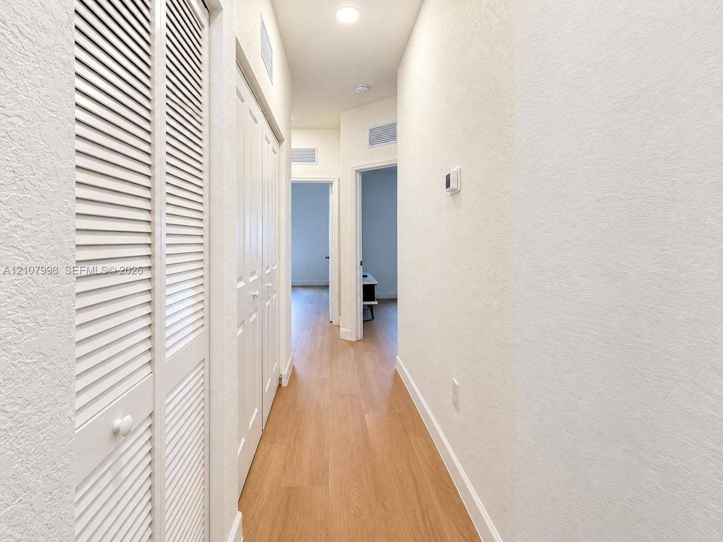23471 SW 129th Avenue, Homestead, Homestead, FL 33032 Hallway featuring wood-finish flooring, white louvered-style closet doors, and recessed lighting